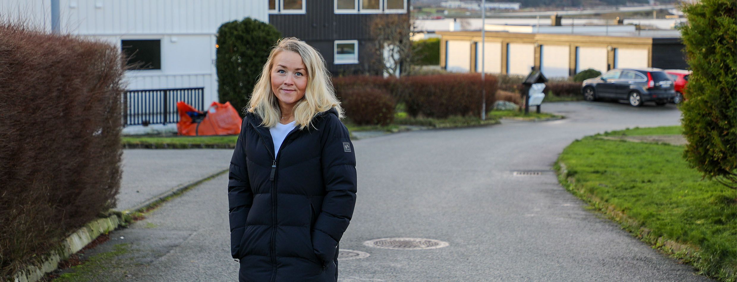 Kvinne står foran husene i et borettslag