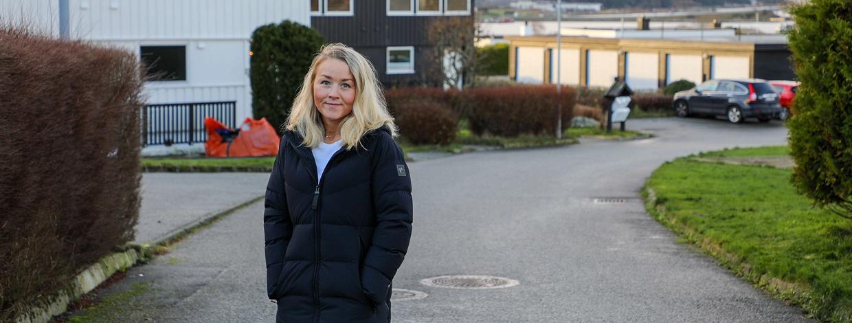 Kvinne står foran husene i et borettslag