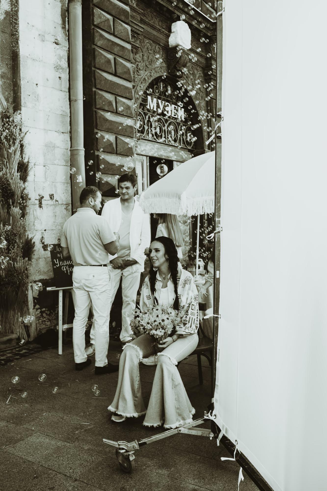Vertical shot of a model in a stylish outfit leaning against an old Lviv doorway, artistic film-inspired photography.