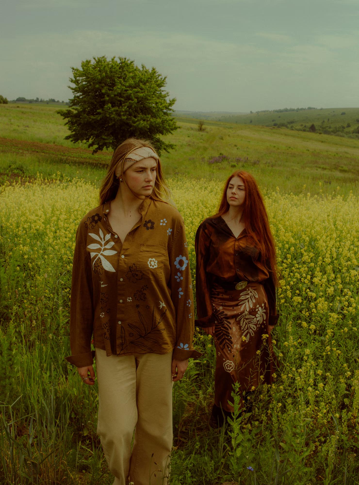 Full body fashion campaign shot of woman in rich brown Ukrainian designer ethnic outfit standing in poppy field, warm autumn tones, Ukraine editorial