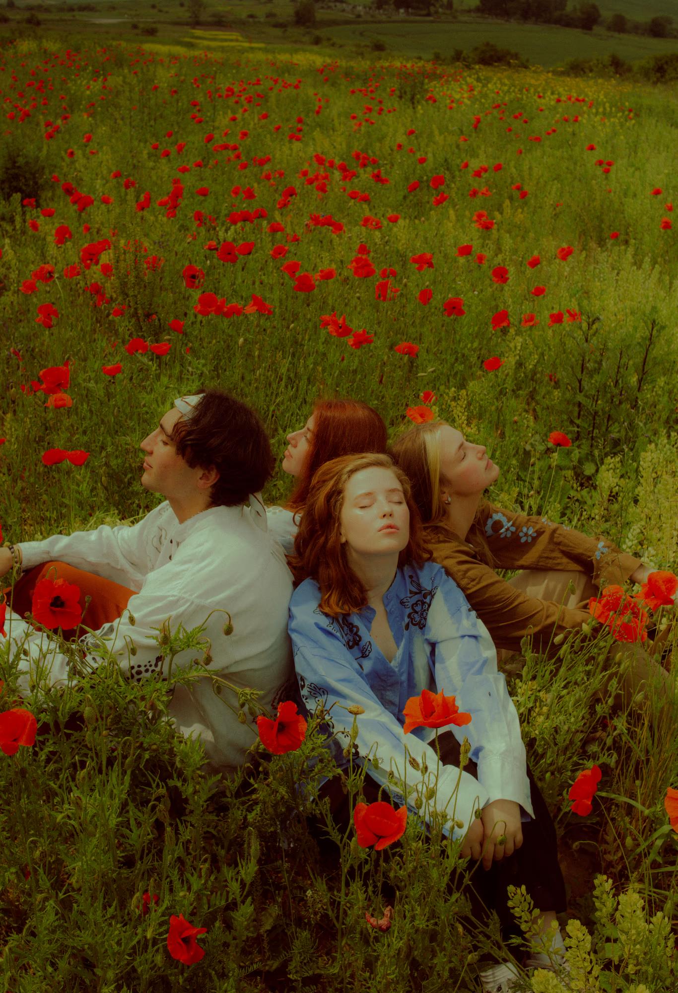 Medium fashion campaign shot of woman in Ukrainian designer outfit surrounded by red poppies in bloom, warm cinematic tones, Ukraine countryside