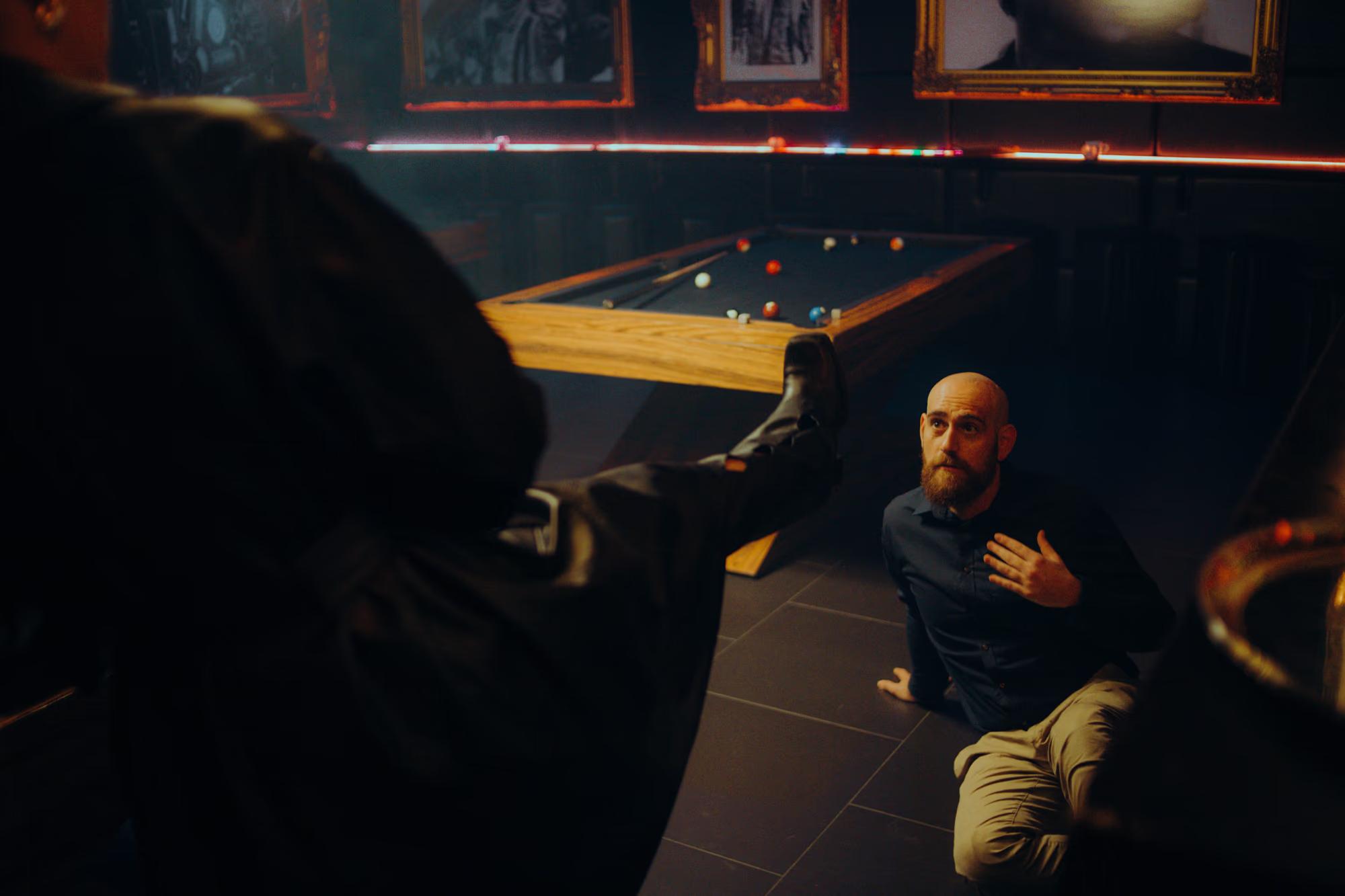 Over-the-shoulder shot of a camera operator capturing a fast-paced combat scene in a dark venue.