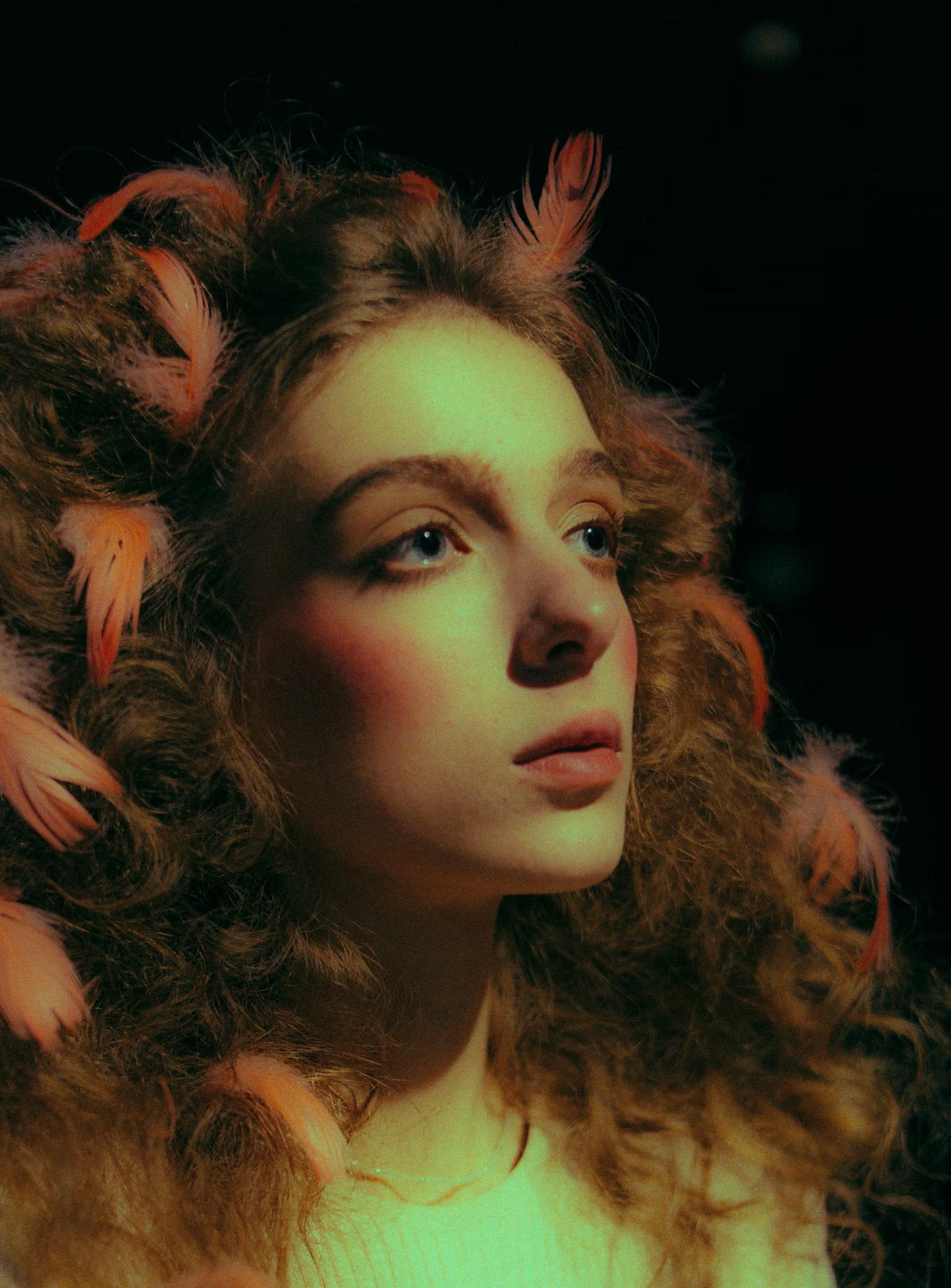 Soft-focus macro portrait of a redhead model’s face, ethereal theatrical lighting.