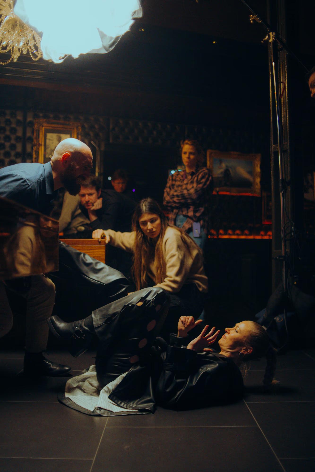 Behind-the-scenes: A makeup artist performing touch-ups on an actor during an intense night shoot.