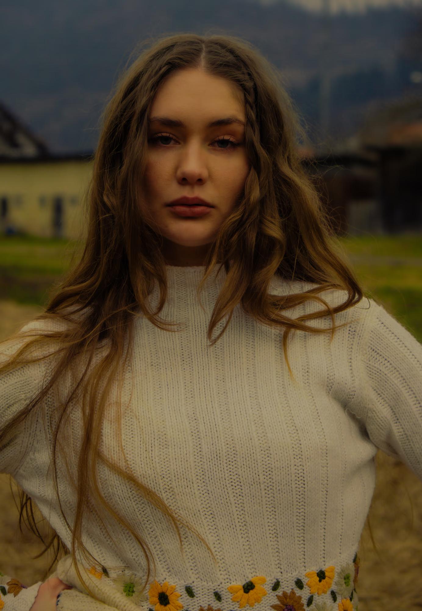 Close-up fashion portrait of woman with long dark hair in white traditional-style blouse, soft natural light, Carpathian ethno fashion editorial