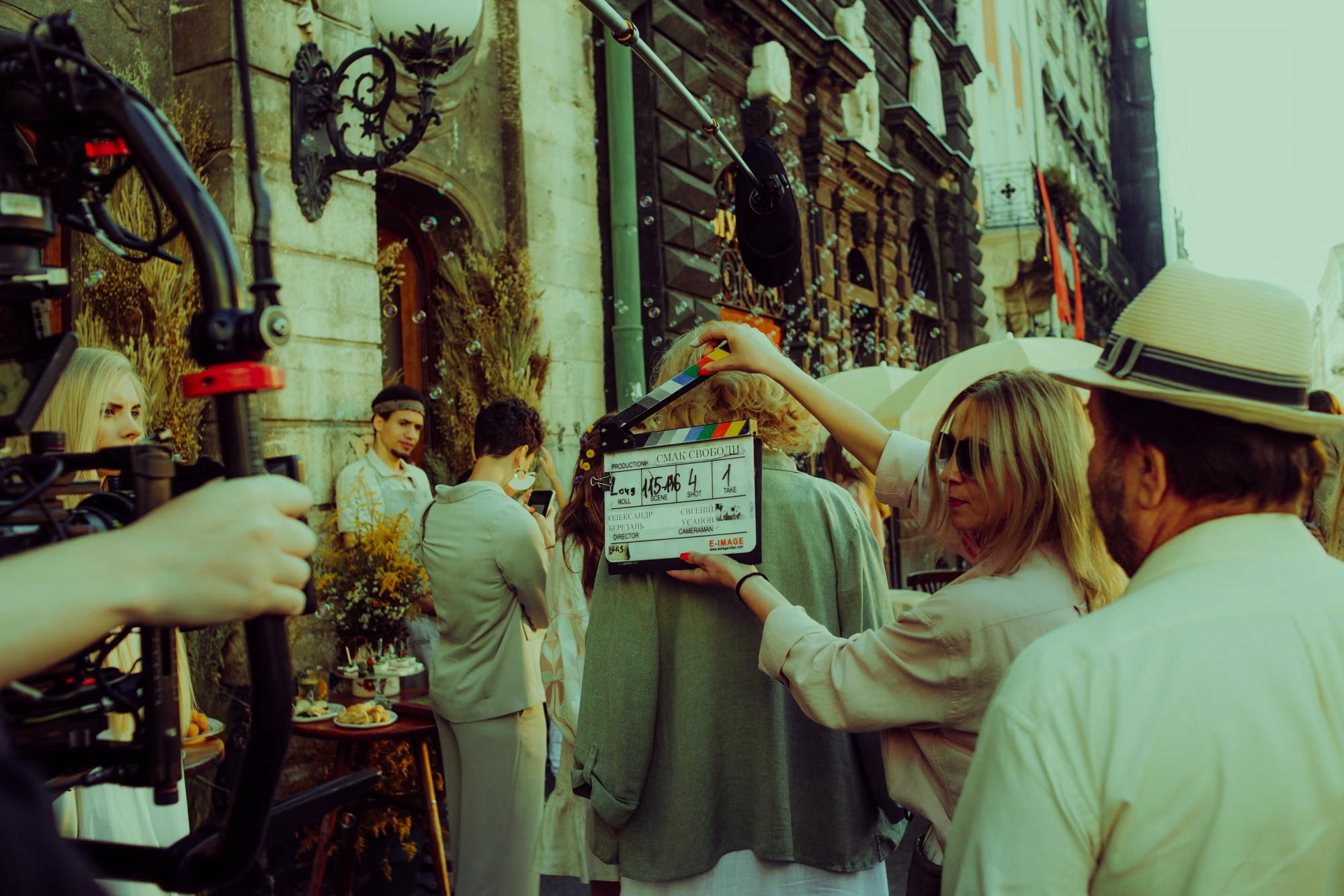 Close-up of a film slate (clapperboard) and vintage-style costumes, preparing for a period drama shoot in Lviv.