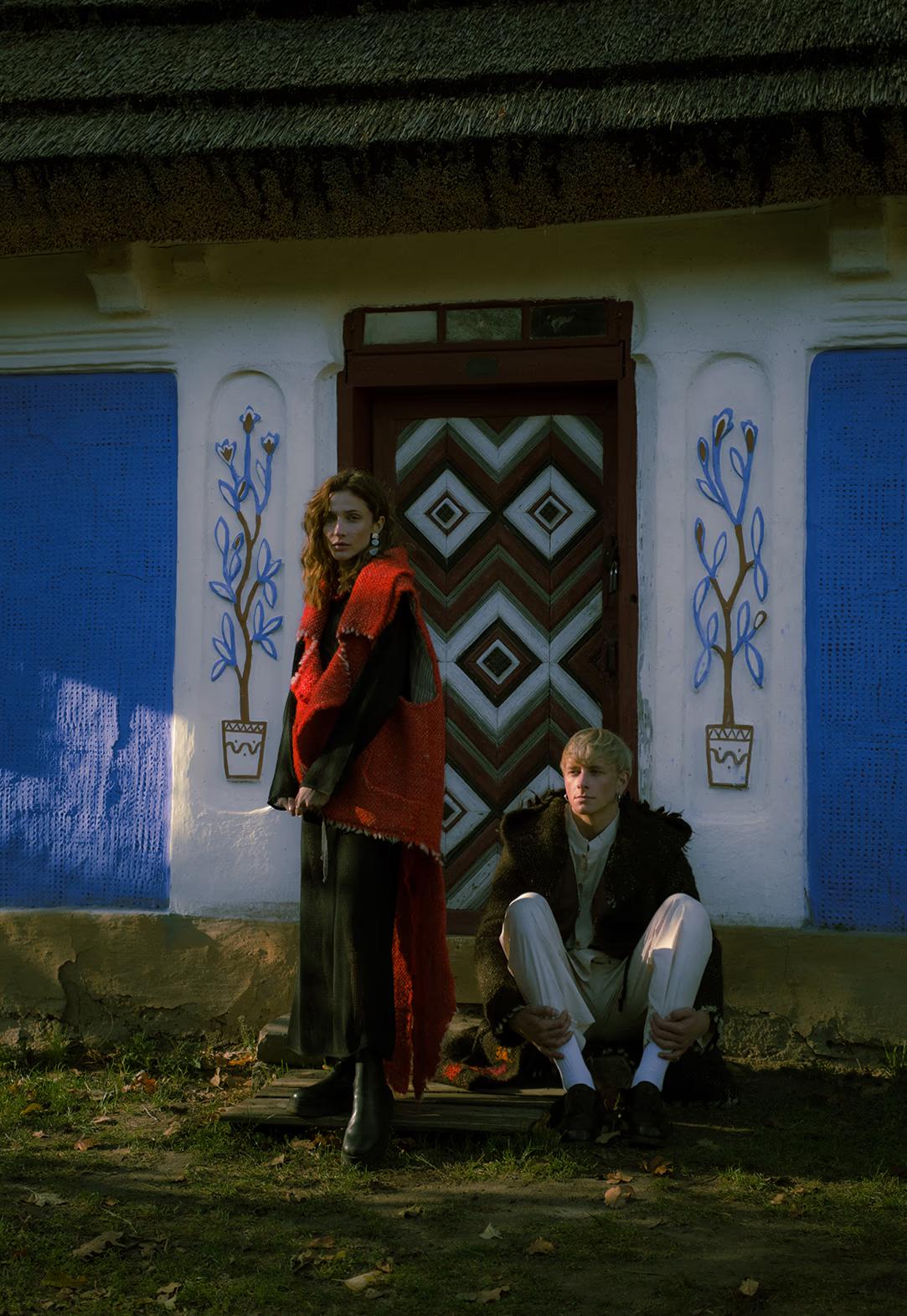 Group fashion pose in front of a decorative blue-trimmed traditional house, highlighting the "Scandi-ethno" aesthetic in Ukraine.