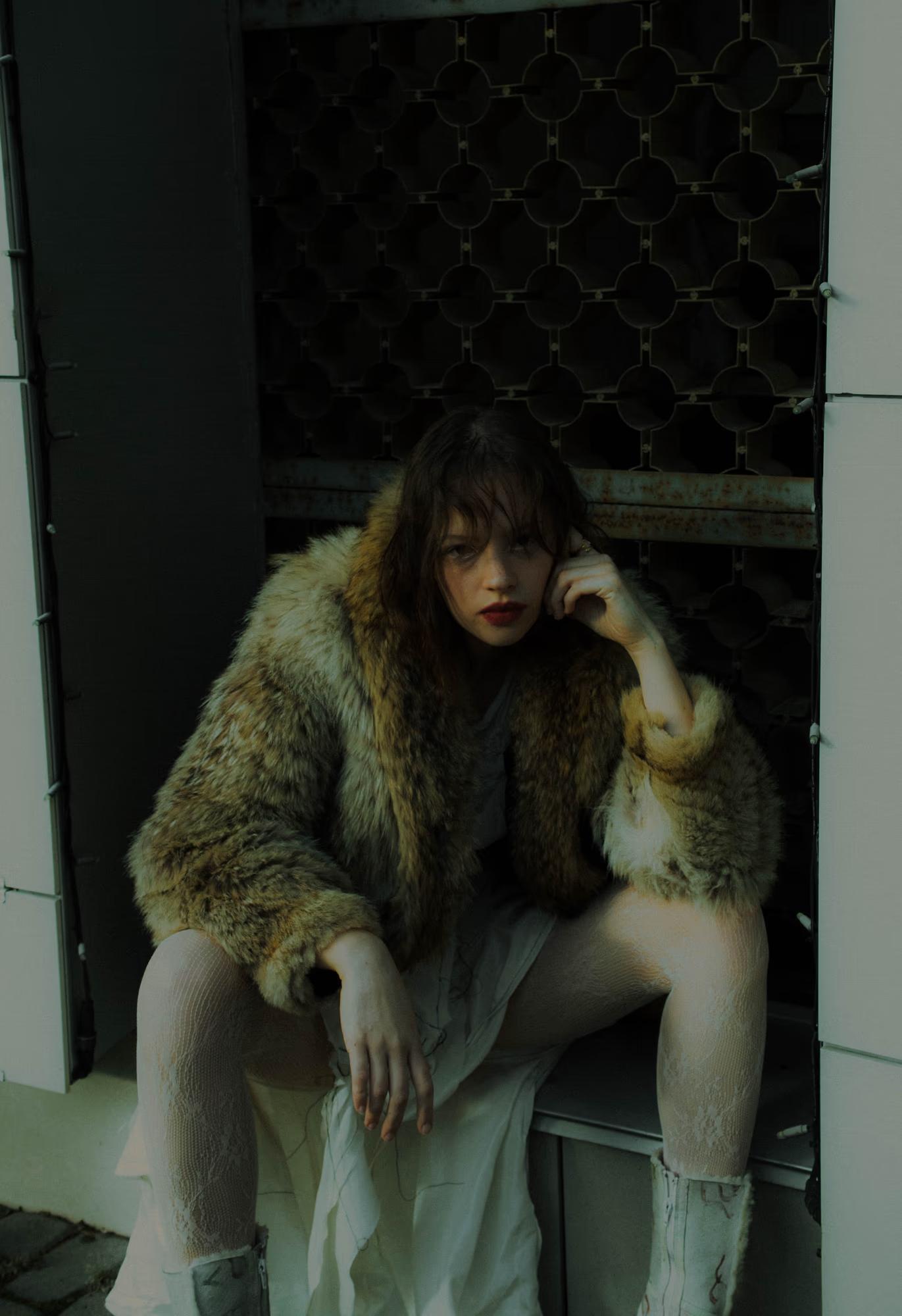 Medium fashion art shot of woman in fur coat in dark forest with wolf or large dog beside her, mysterious dark fantasy editorial