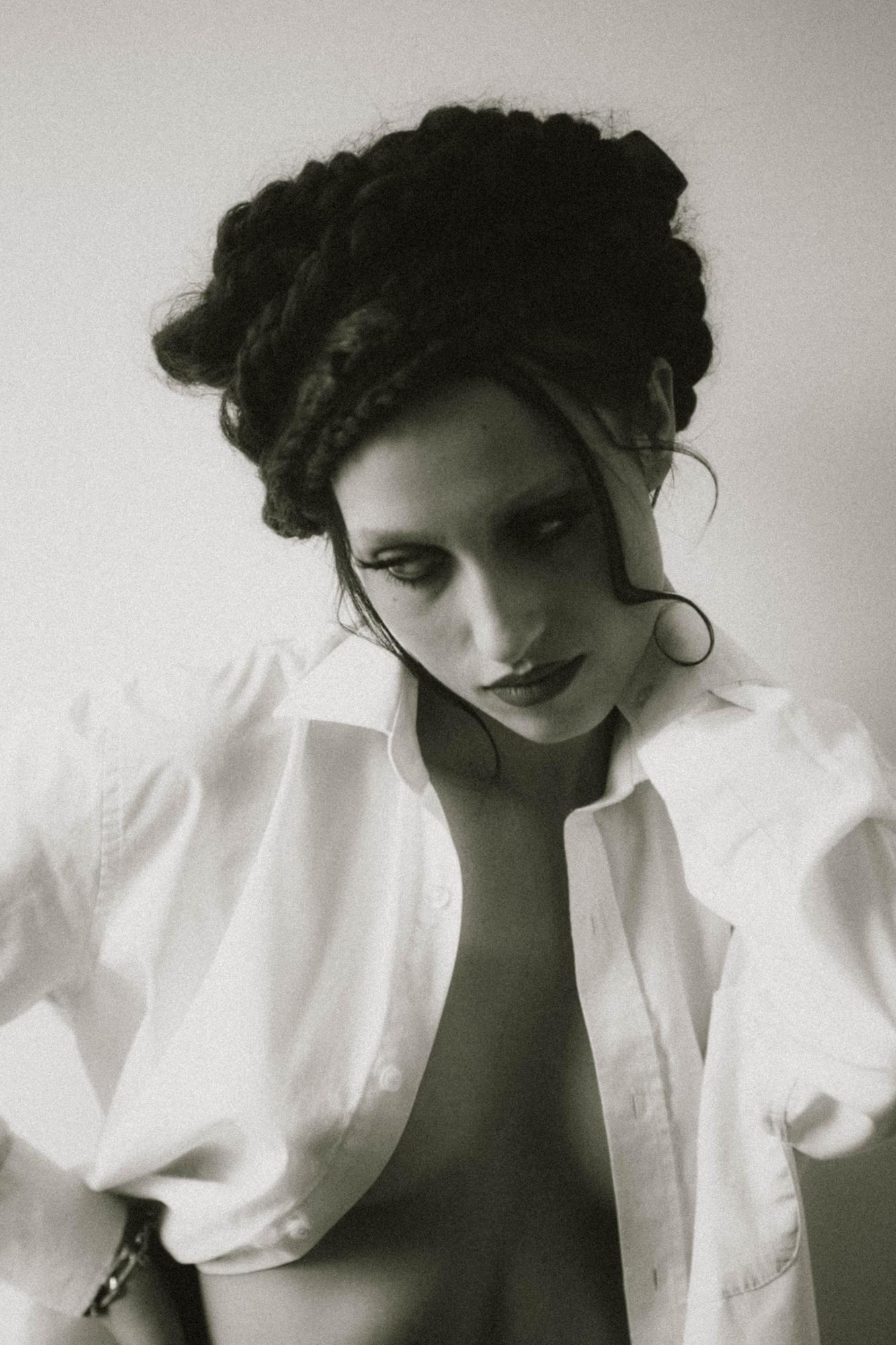 Close-up black and white portrait of woman with hair up, soft light, elegant editorial style
