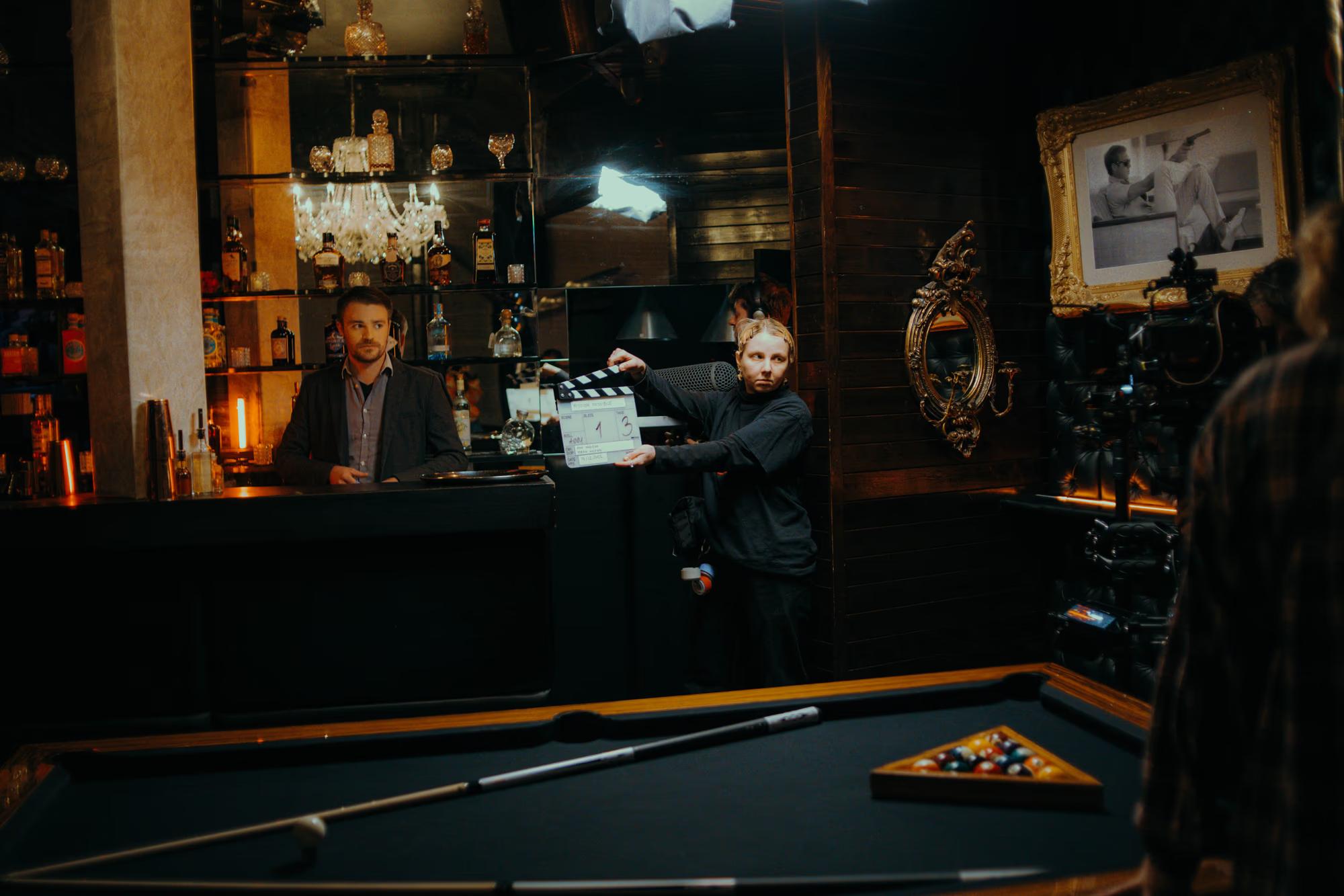 View of the camera monitor and director's station in a crowded, atmospheric pub film location.