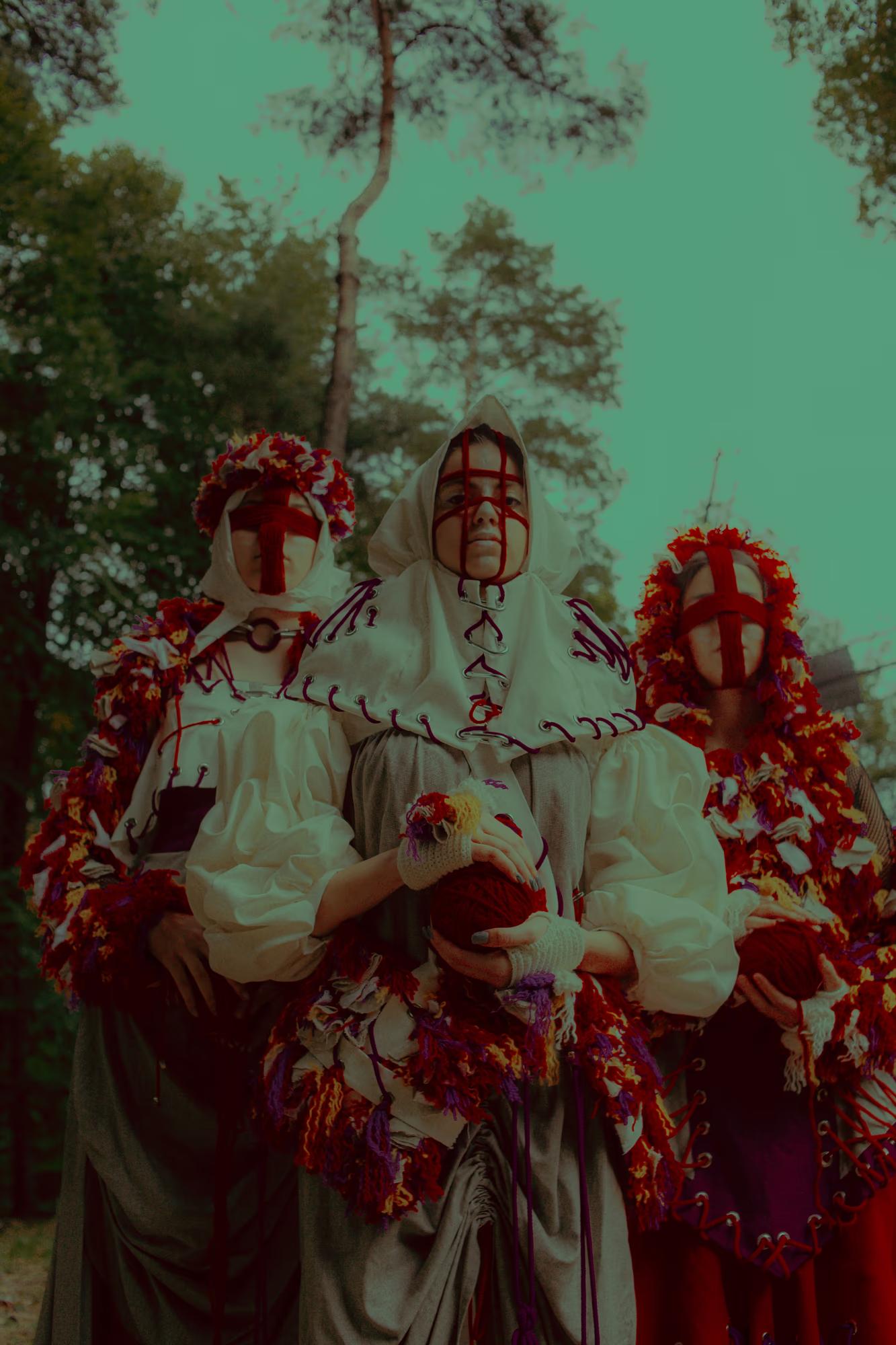 Close-up group portrait showing the intricate details of floral headbands and red-and-white embroidered textiles in a natural outdoor setting.