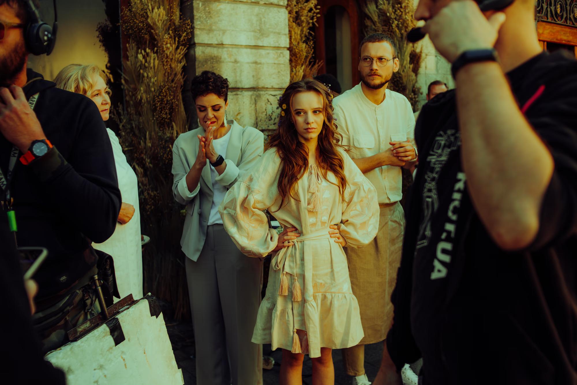 Focus on the director's monitor and the crew observing a performance on set in a historic Lviv venue.