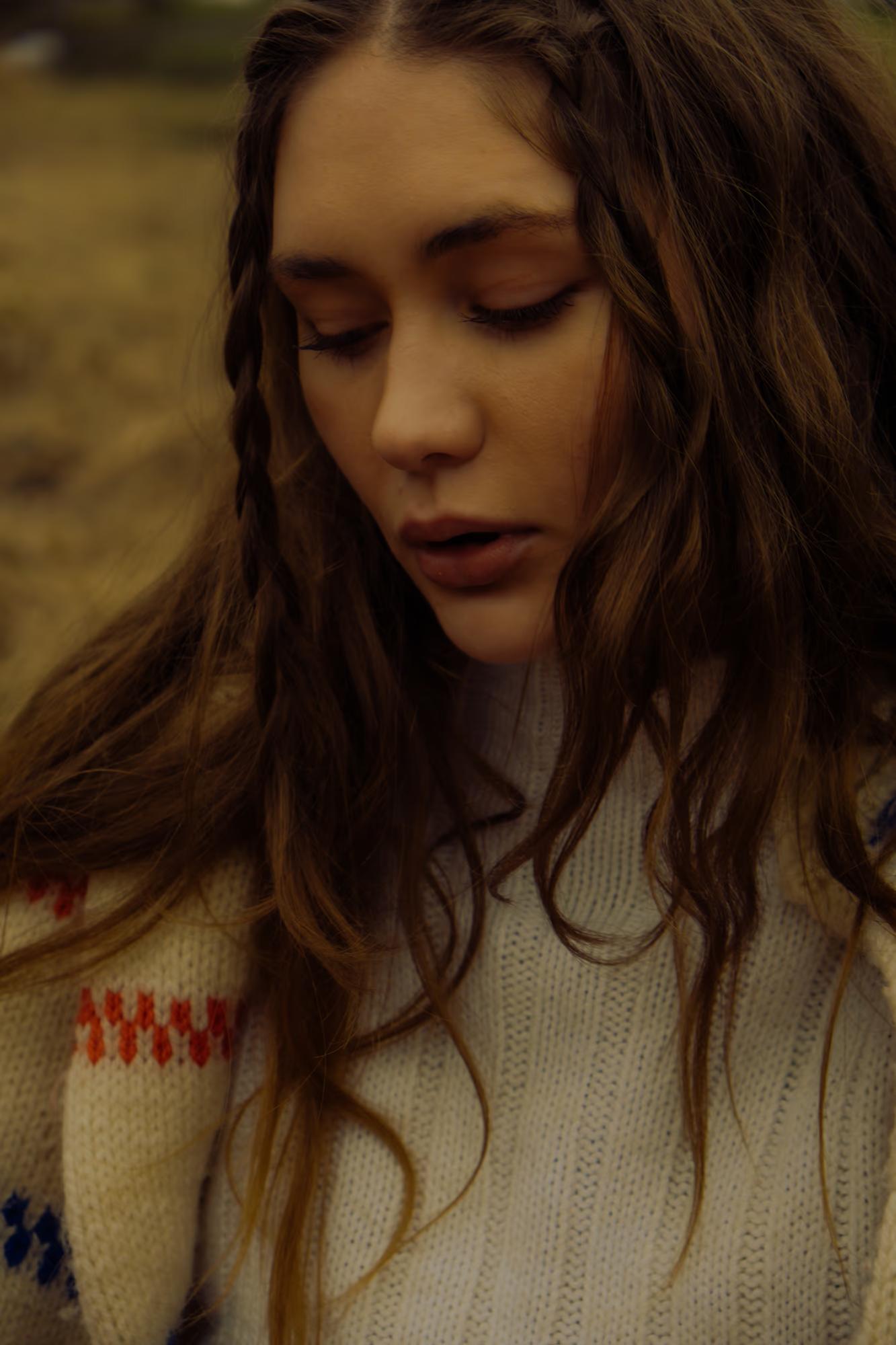 Close-up fashion portrait of woman with long dark hair in white blouse, warm moody tones, Carpathian ethno fashion campaign