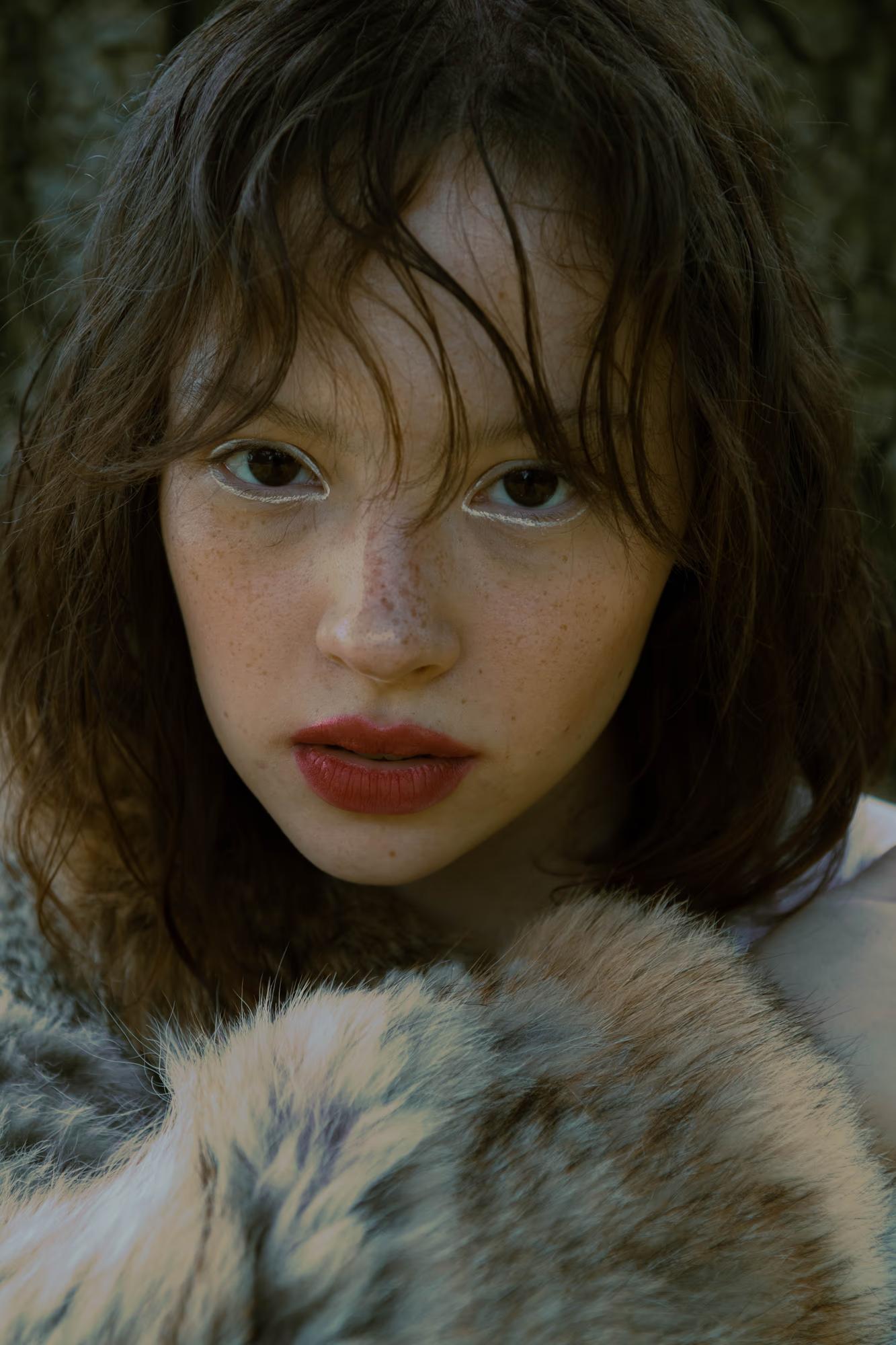 Close-up fashion art portrait of woman in fur coat with bold red lips, intense gaze, dark moody background, dark fantasy editorial