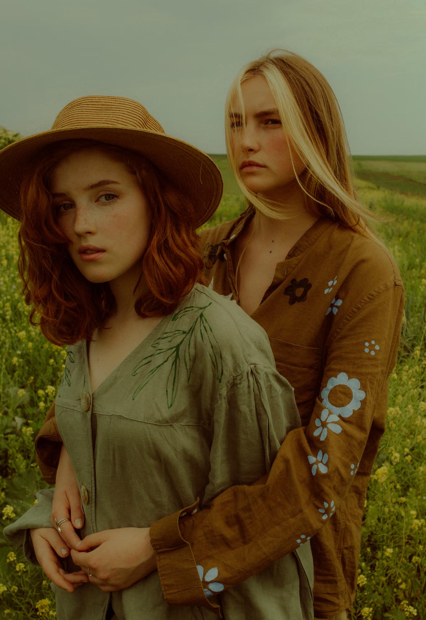 Close-up fashion portrait of woman in designer linen outfit and straw hat among red poppies, warm tones, Ukrainian ethno fashion campaign