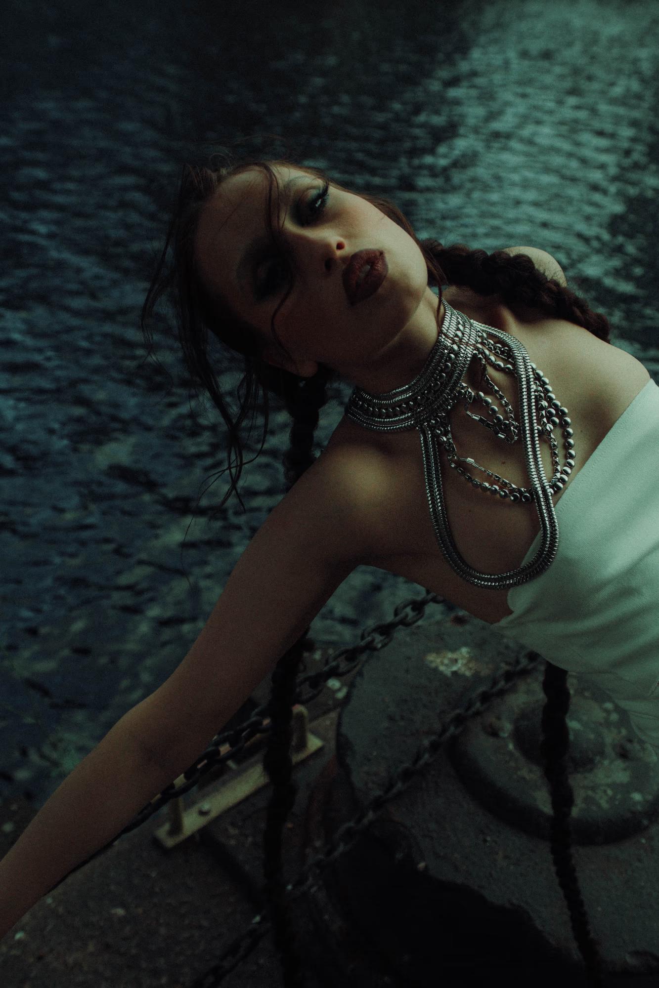Medium shot of woman with flowing hair in motion, dark cinematic editorial, Canary Wharf London docklands
