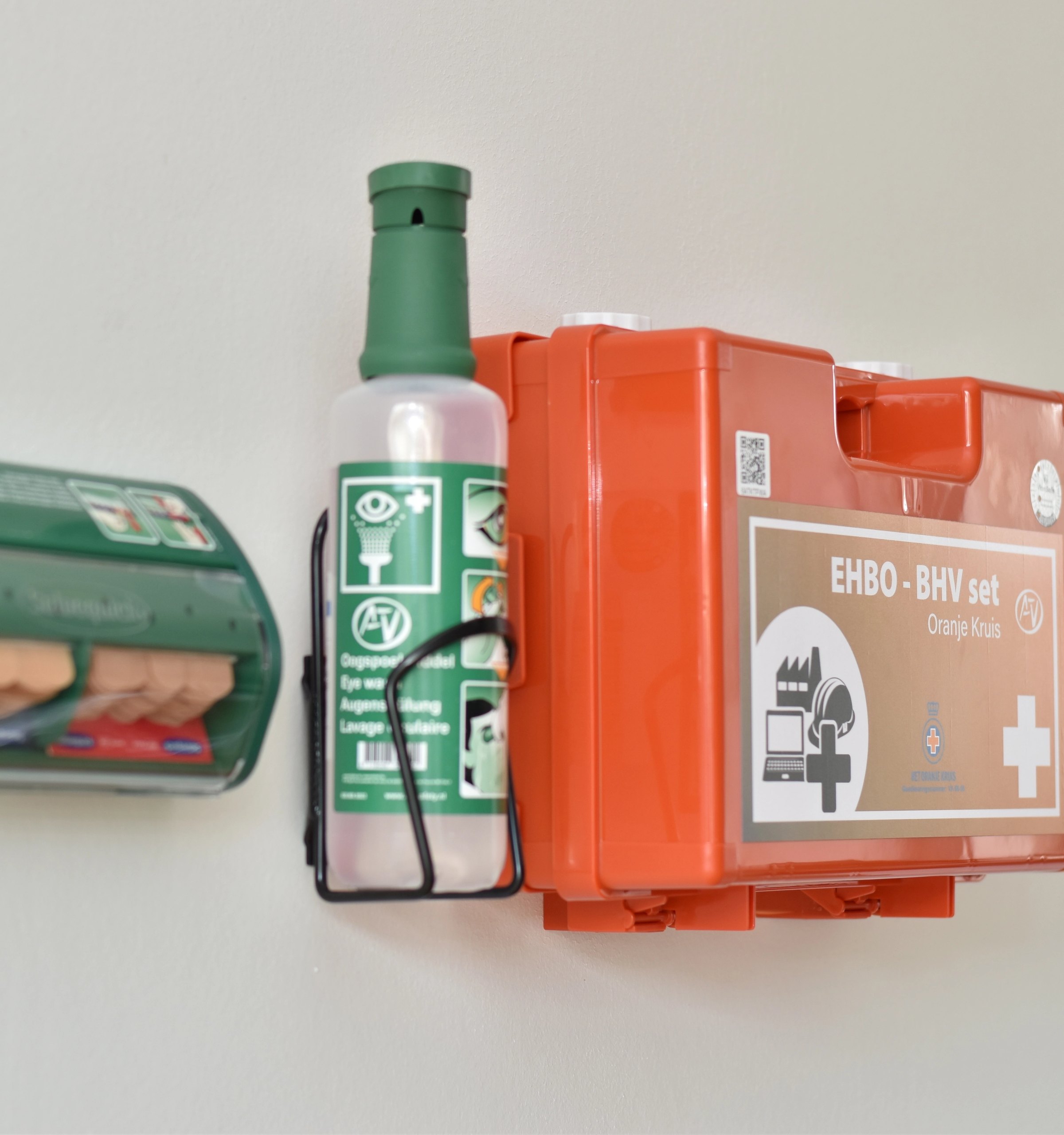 pleisterdispenser oogspoelfles verbandkoffer handbrandmelder op muur