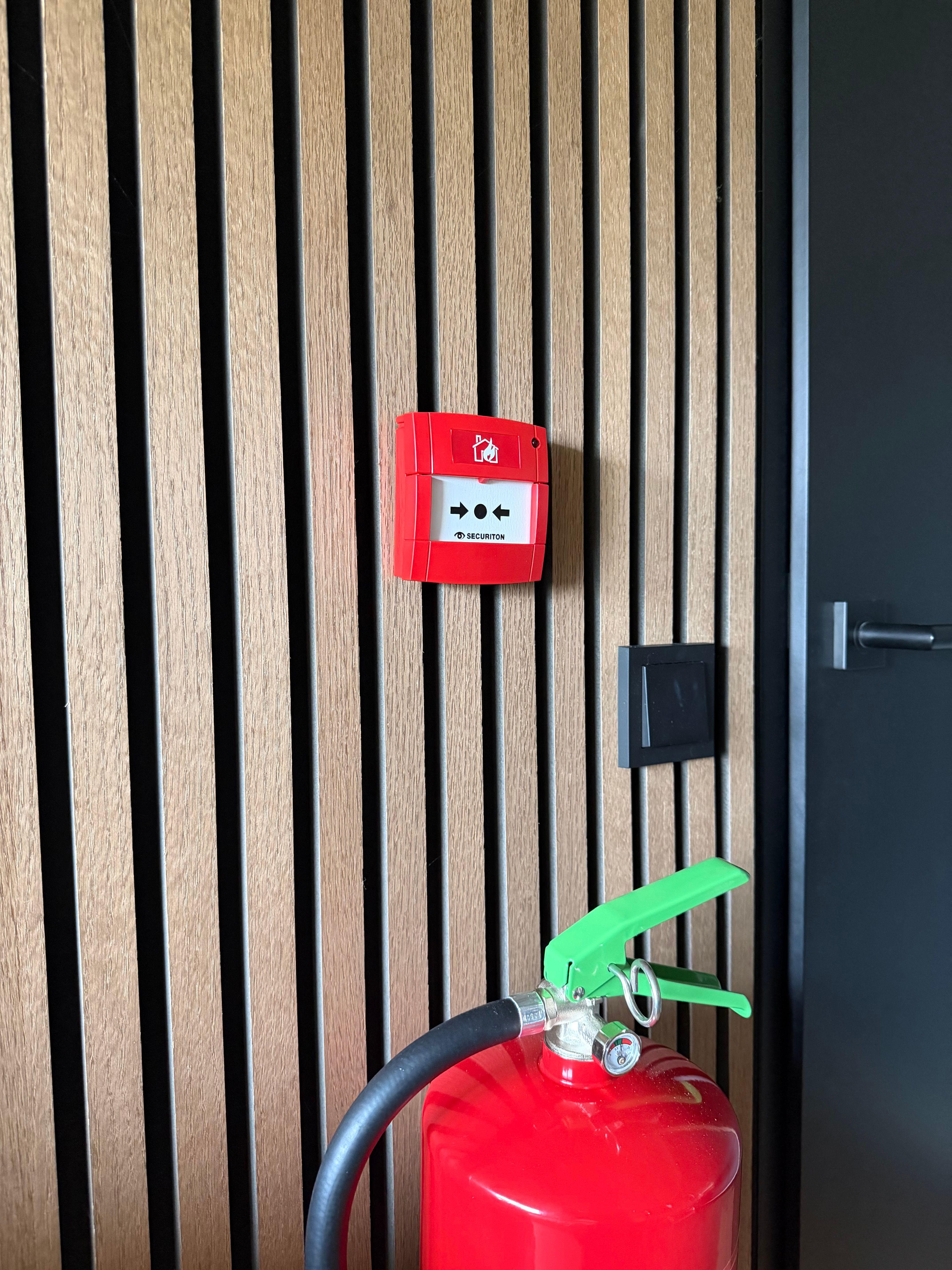 handbrandmelder muur met brandblusser