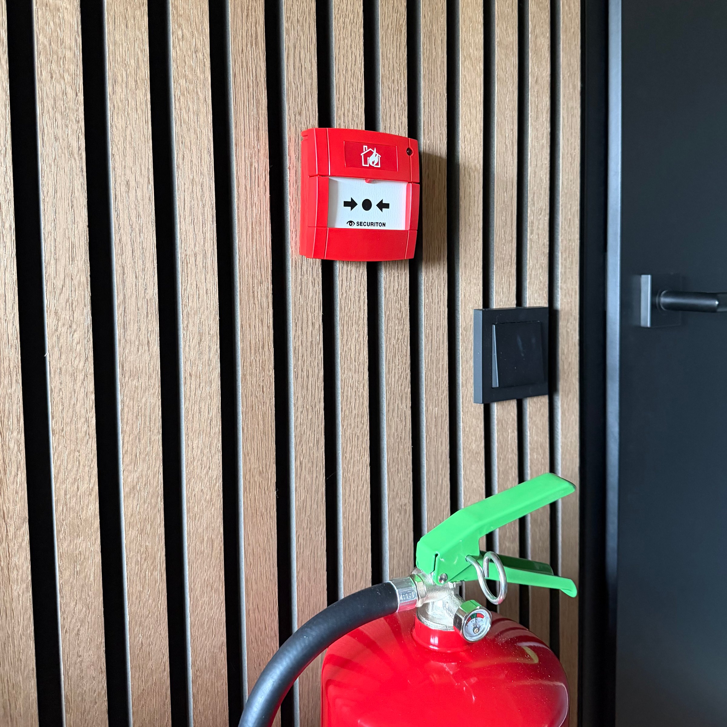 handbrandmelder muur met brandblusser