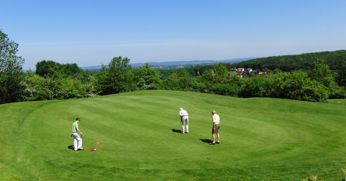 3 golfers putting