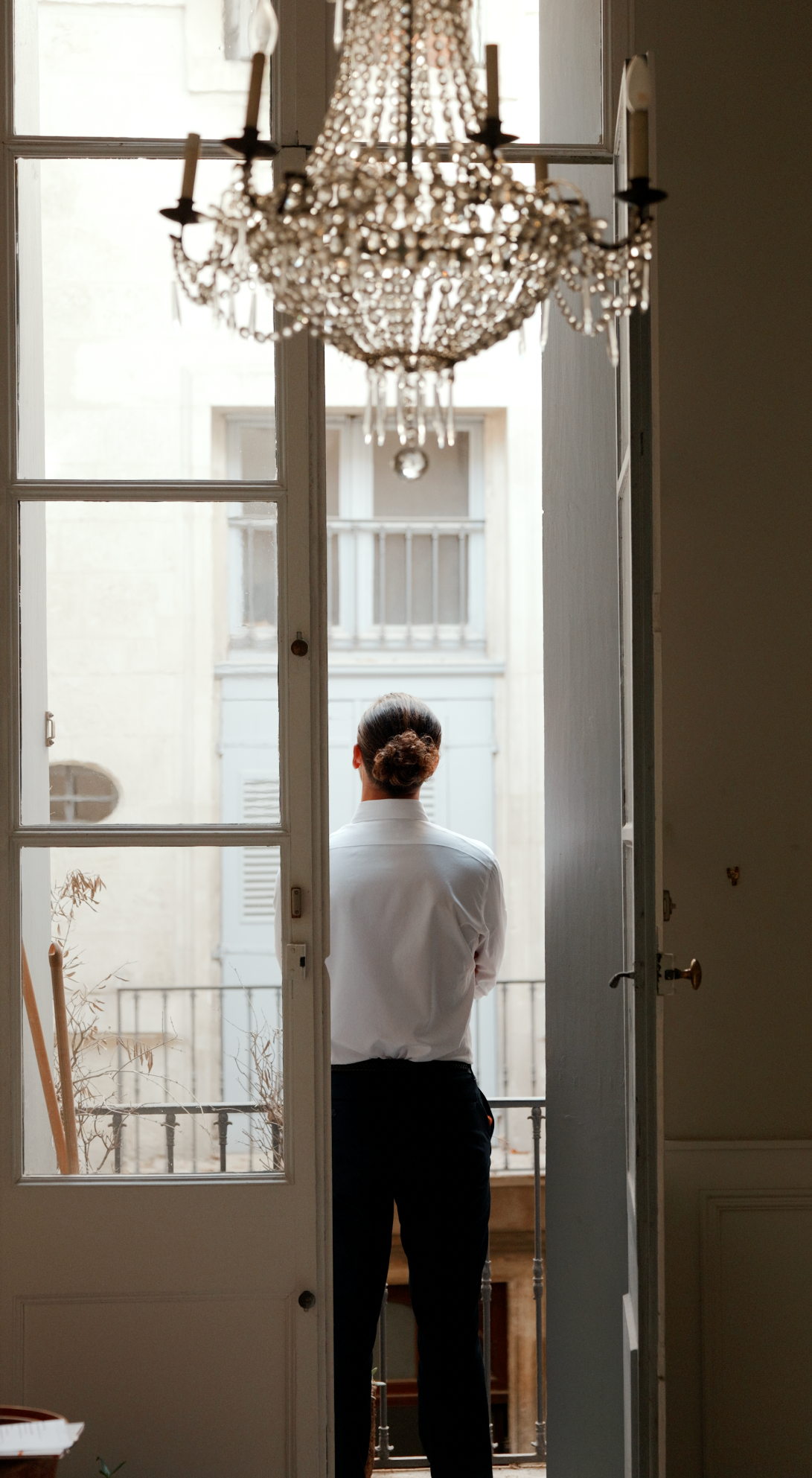 Clément Psaltis au balcon d’un appartement ancien, lustre en cristal
