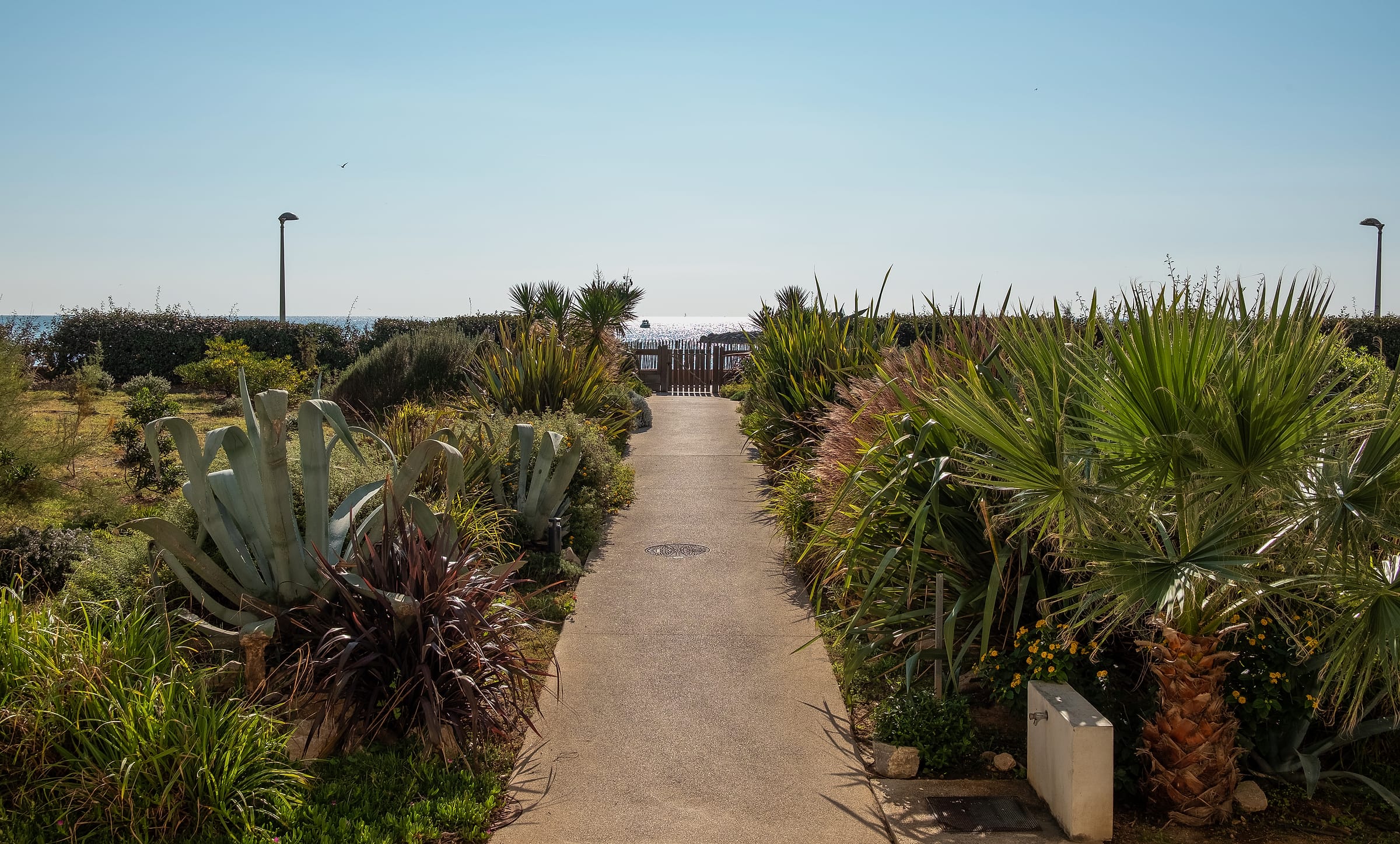 Allée du jardin de la résidence menant à la plage