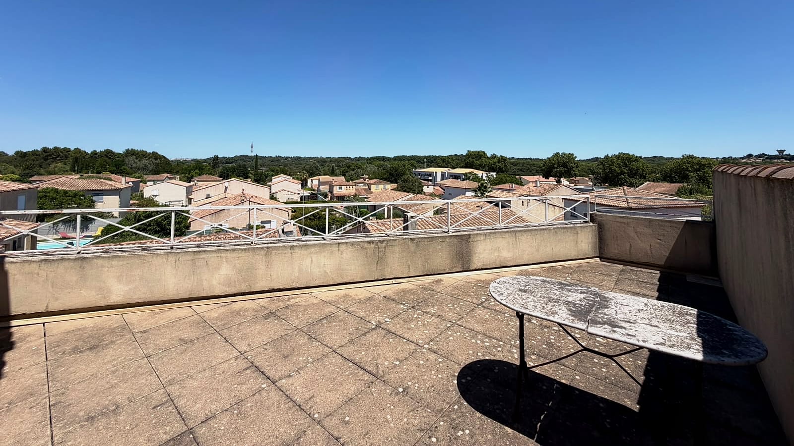 Terrasse privative de l’étage, avec vue dégagée sur les toits et la campagne