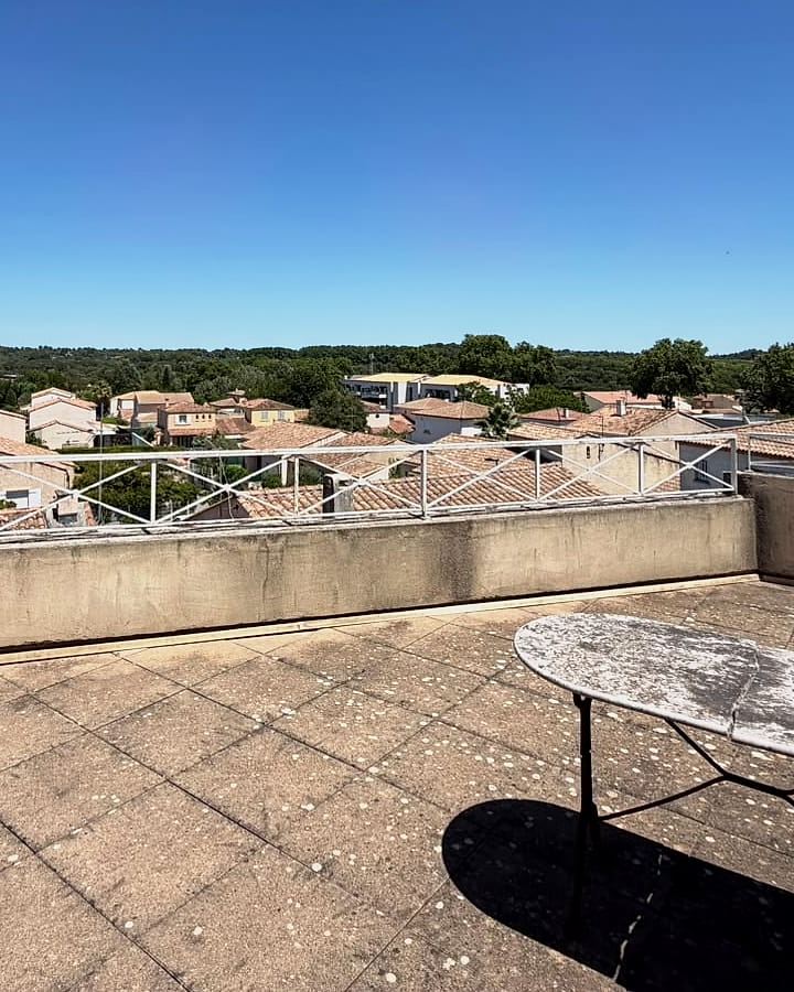 Terrasse privative de l’étage, avec vue dégagée sur les toits et la campagne