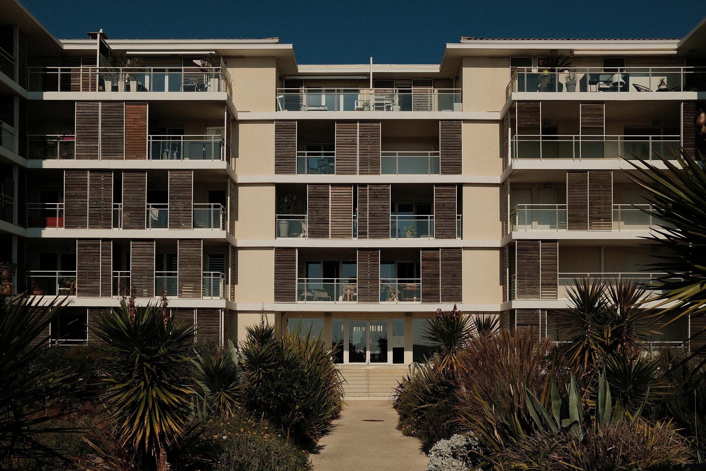Façade de la résidence côté jardin, avec balcons et brise-soleil en bois