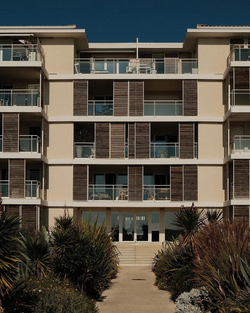 Façade de la résidence côté jardin, avec balcons et brise-soleil en bois