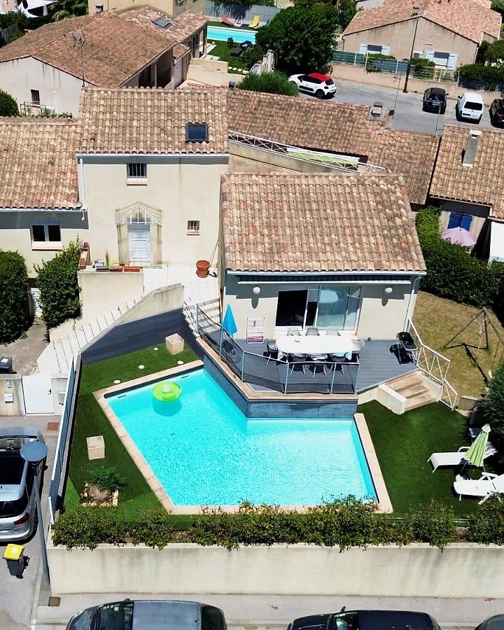 Vue aérienne de la maison, de sa piscine et de son jardin à Lavérune