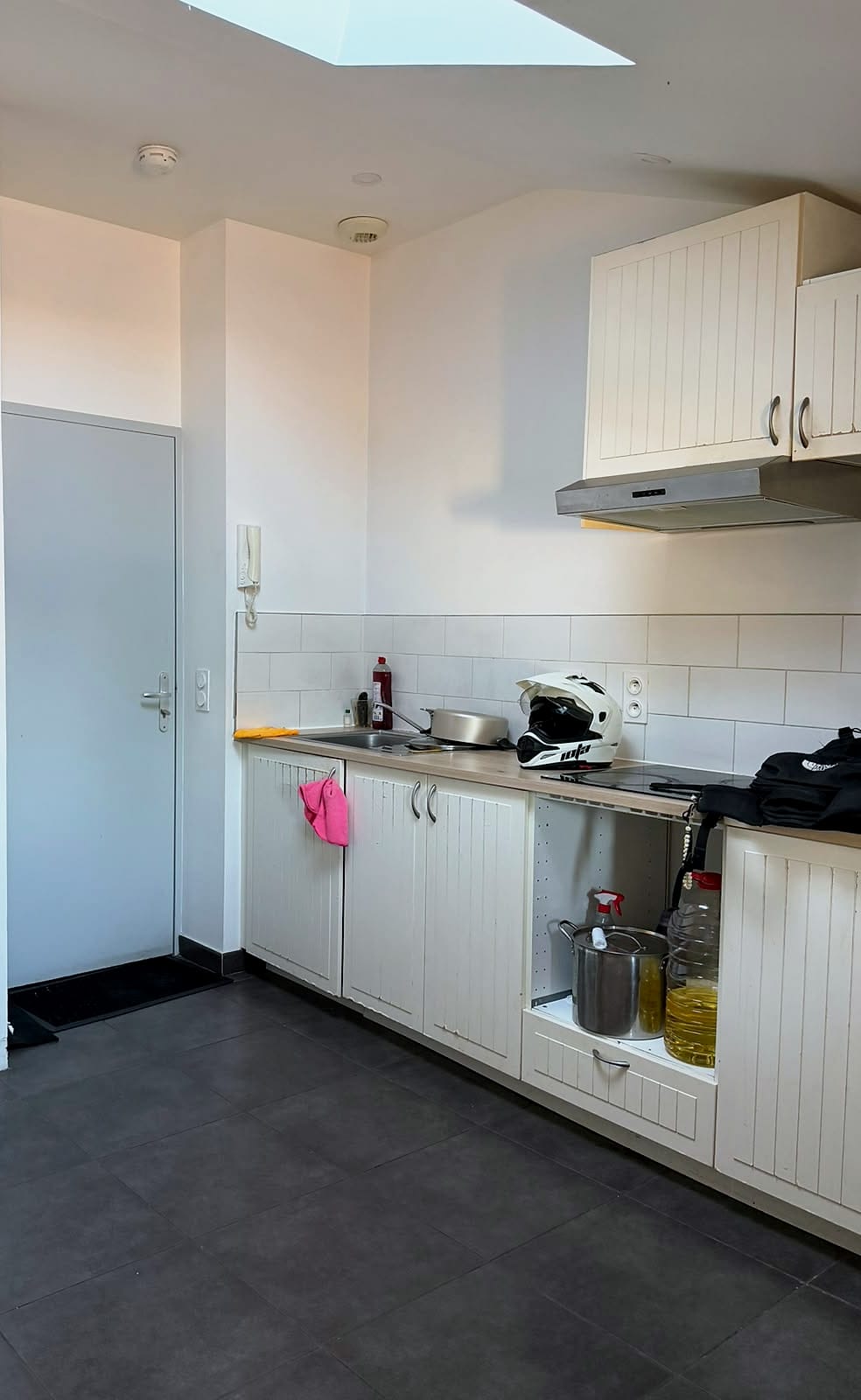 Coin cuisine équipé et porte d’entrée de l’appartement