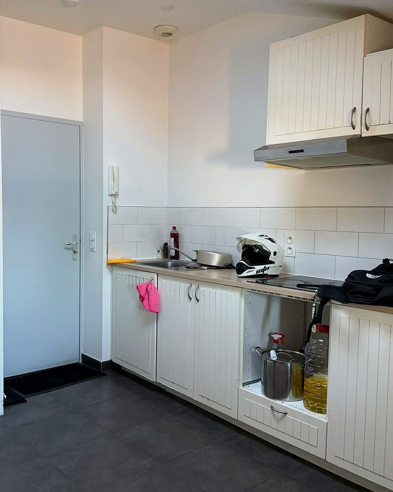 Coin cuisine équipé et porte d’entrée de l’appartement