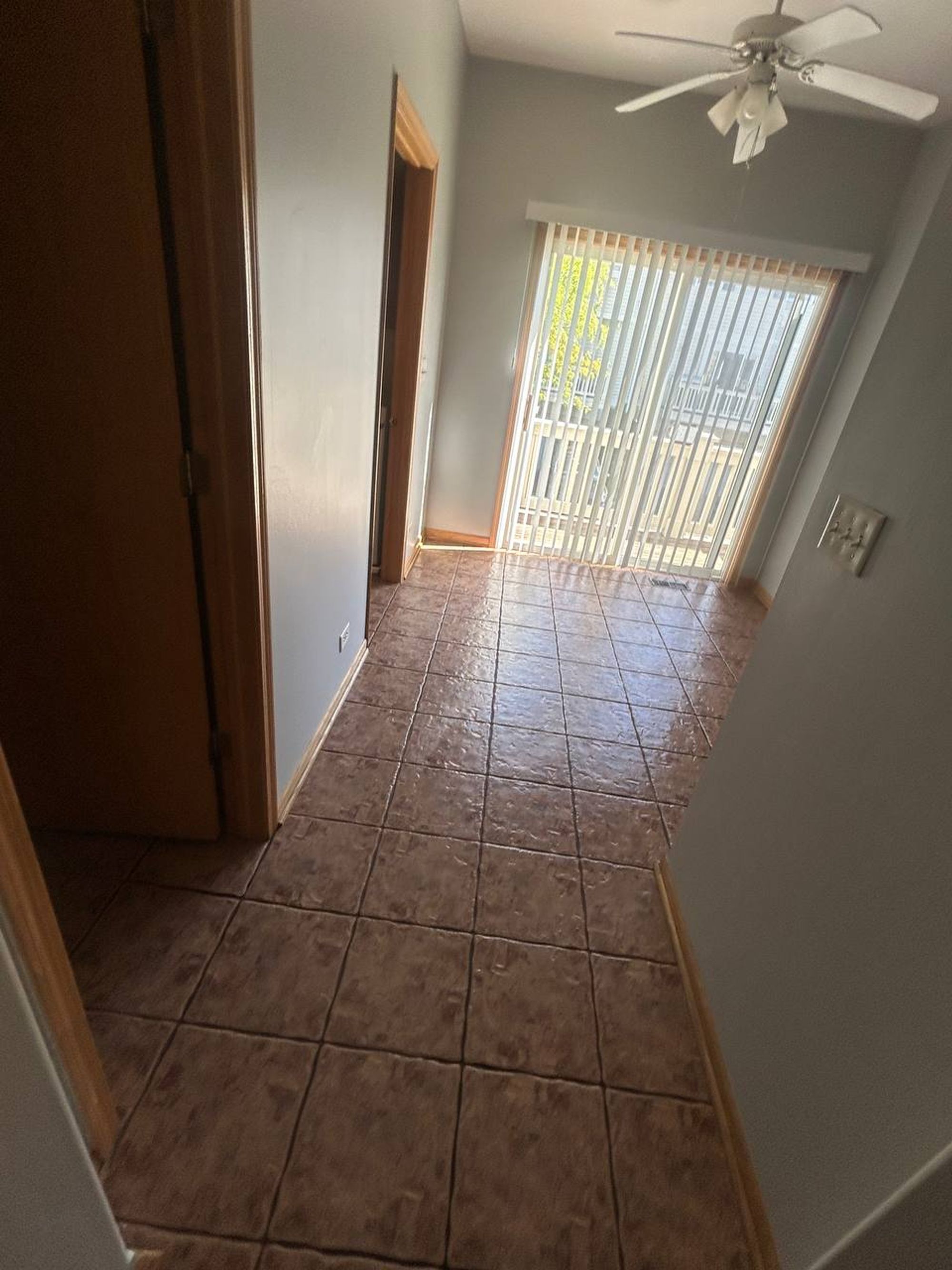 Tiled dining area with sliding door and vertical blinds