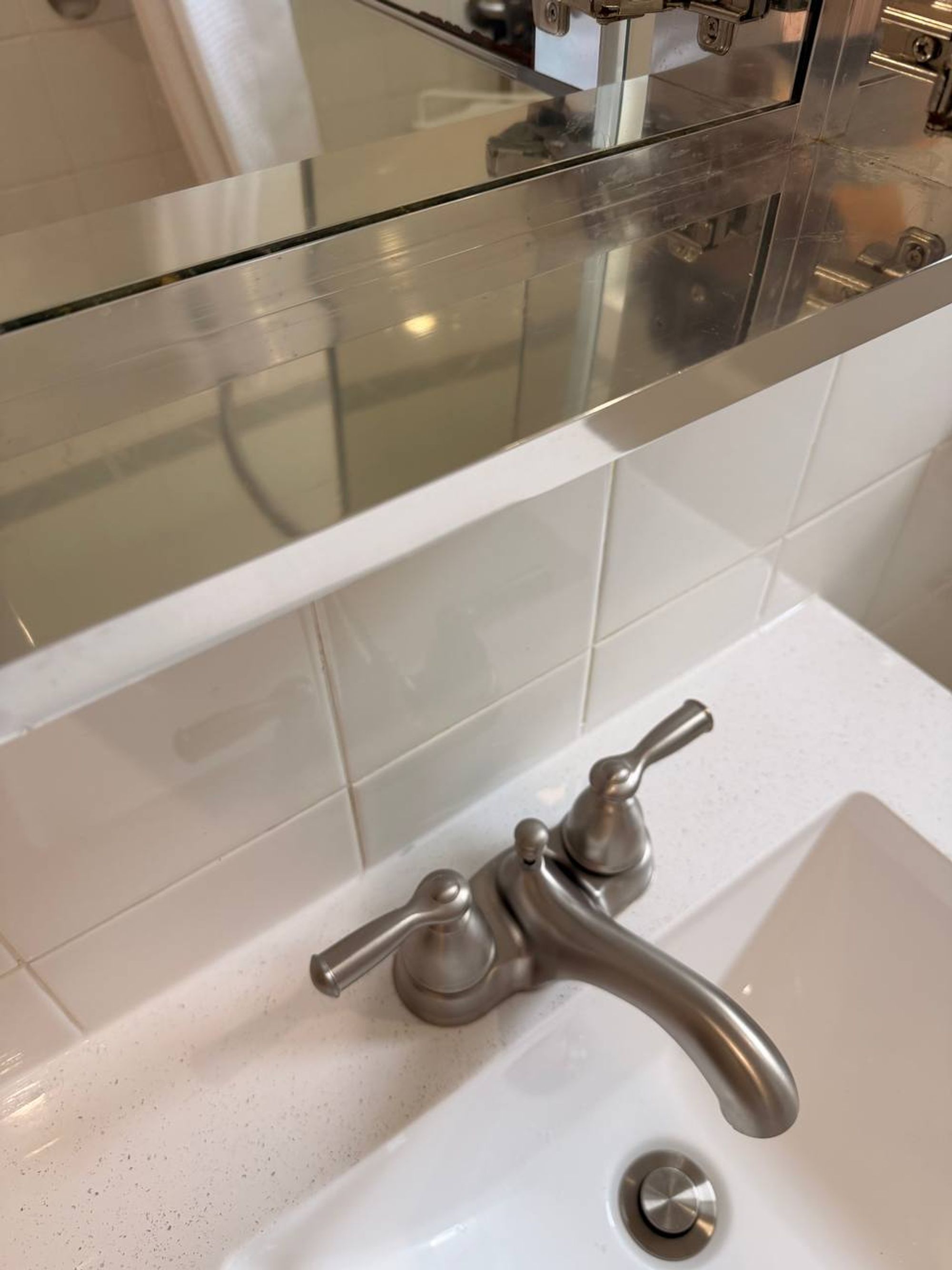 Metal shelf under a medicine cabinet above a clean sink