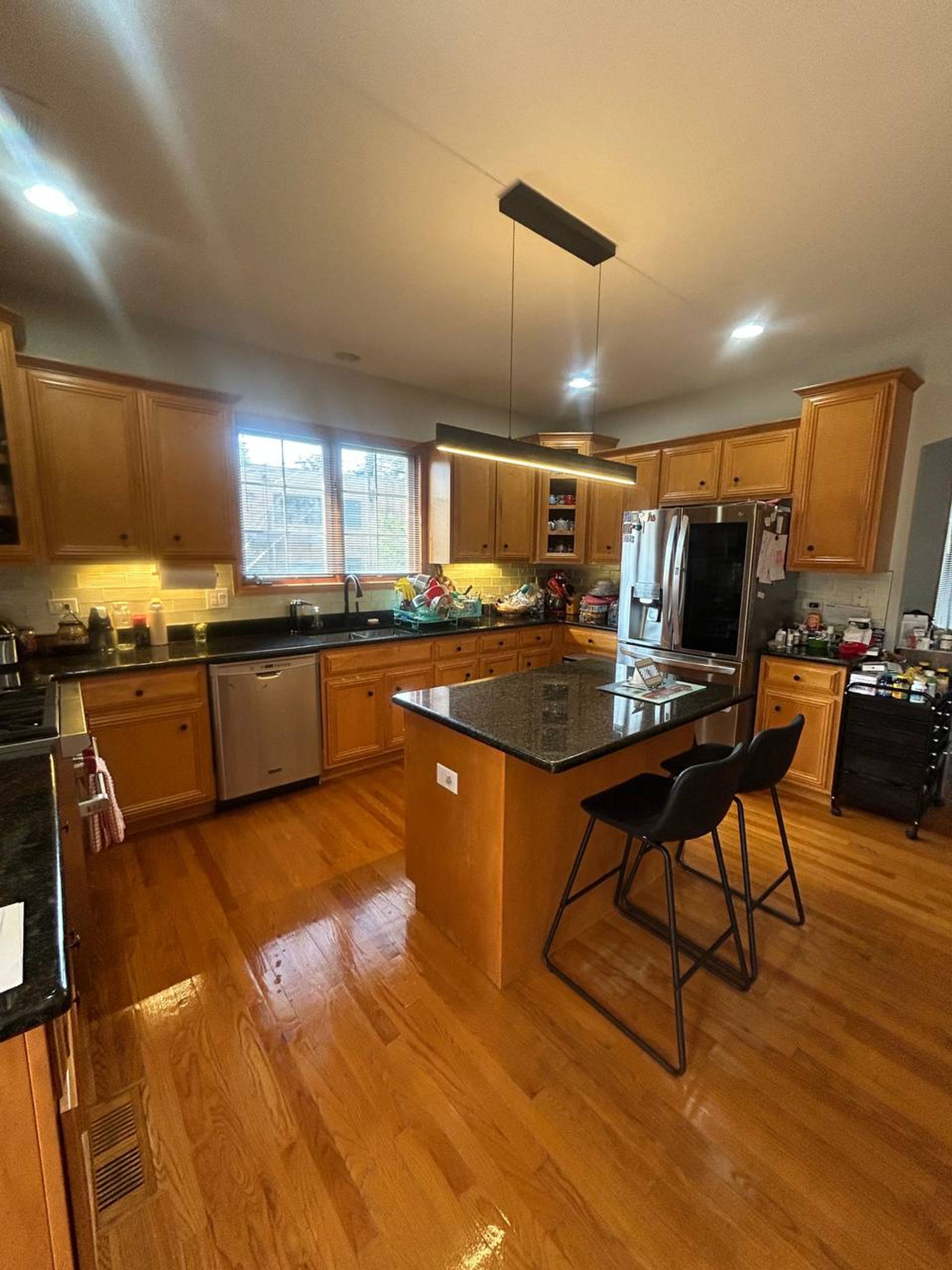 Kitchen with oak cabinets, granite island and shiny hardwood floor