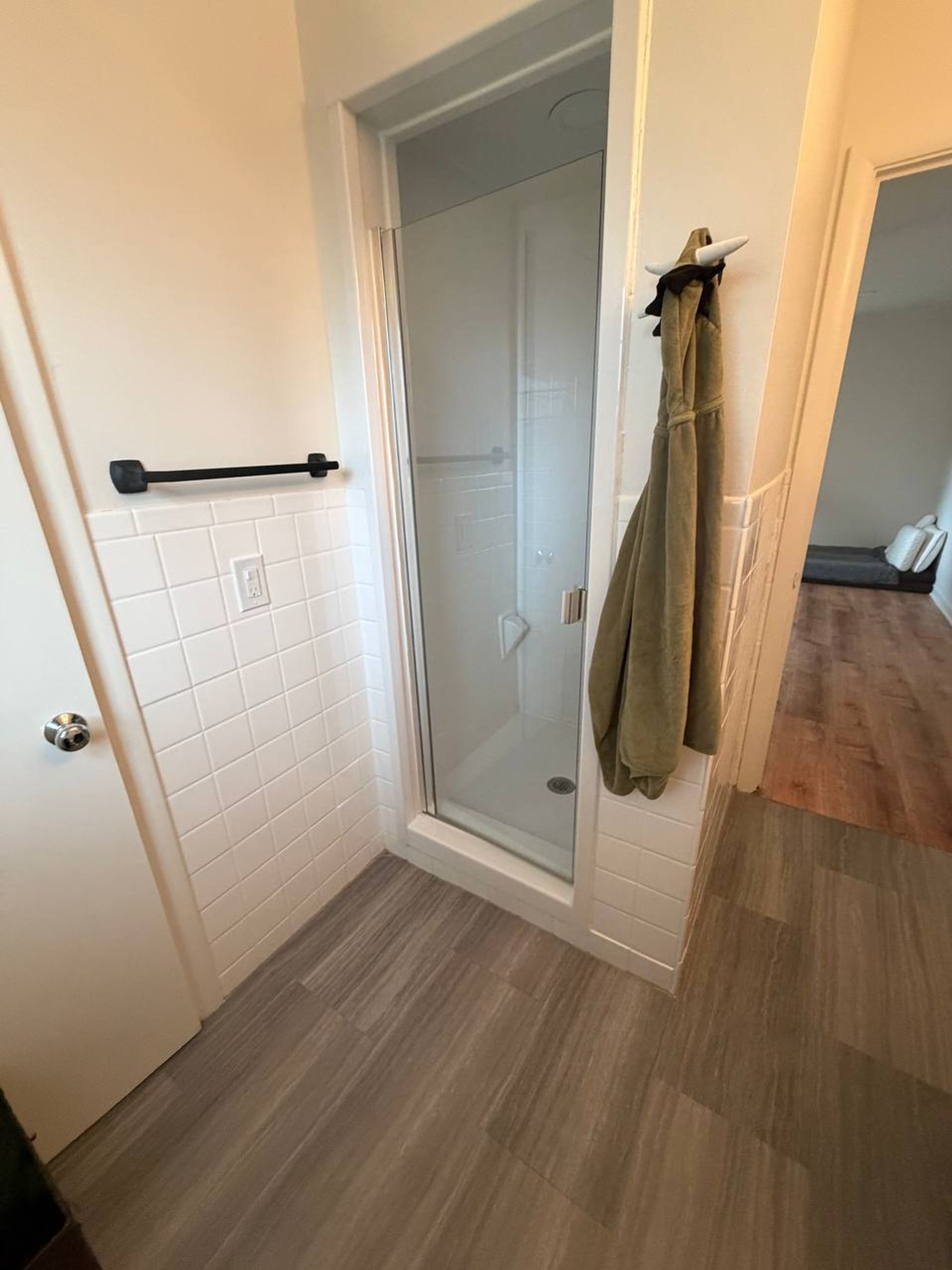 Bathroom corner with a glass shower stall and white tile
