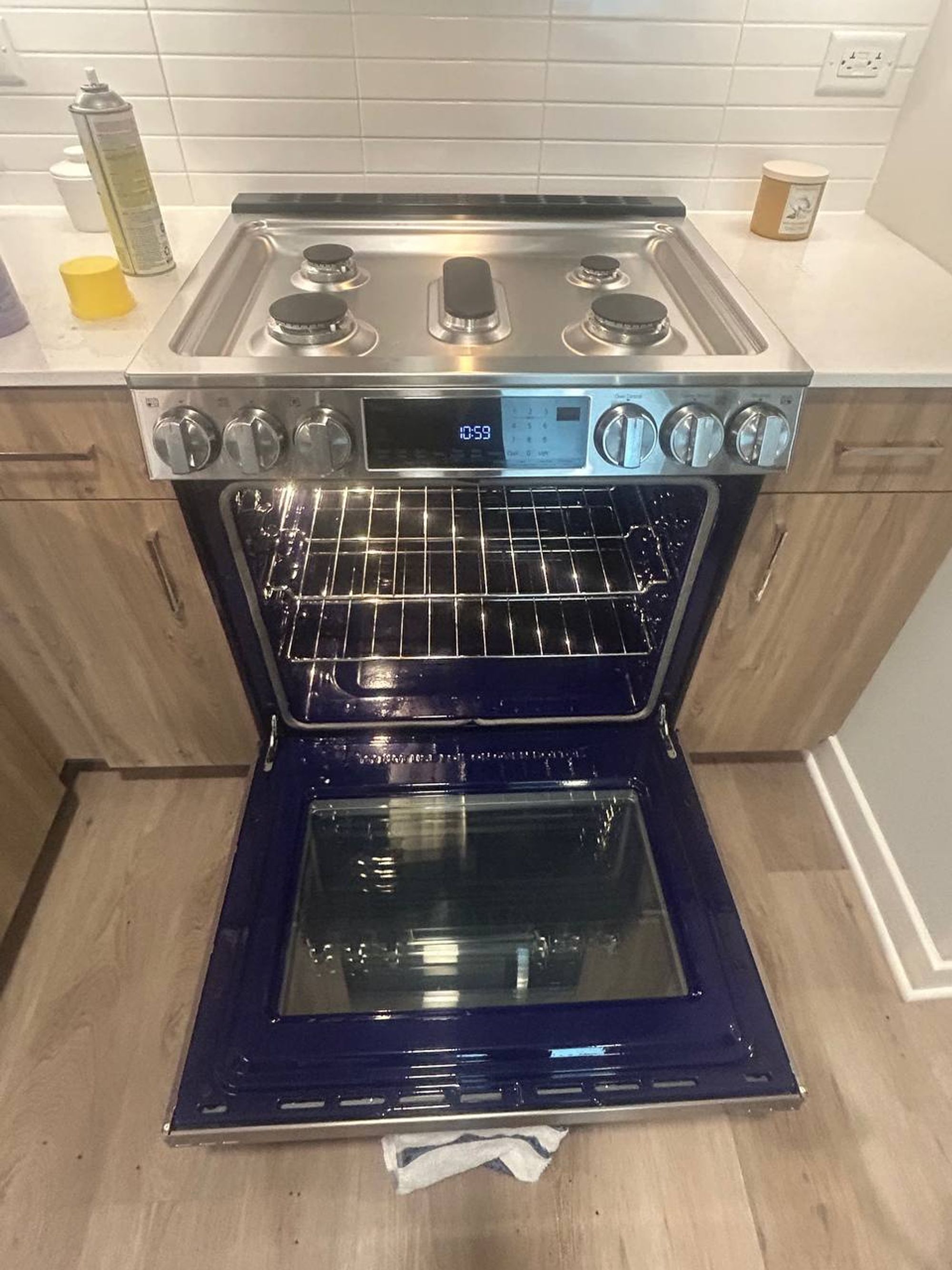 Gas range with oven door open showing clean racks and blue interior