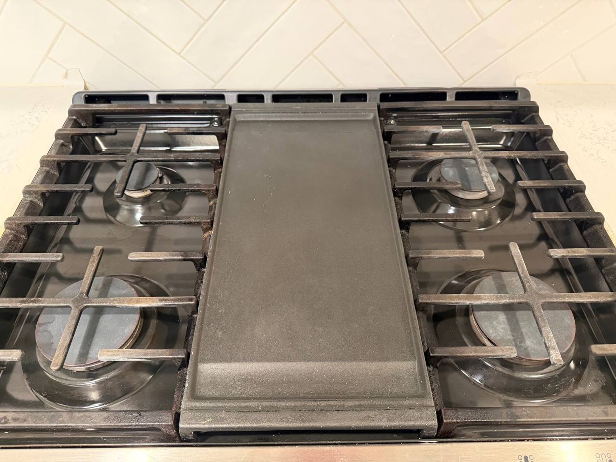 Gas cooktop with clean grates and center griddle plate