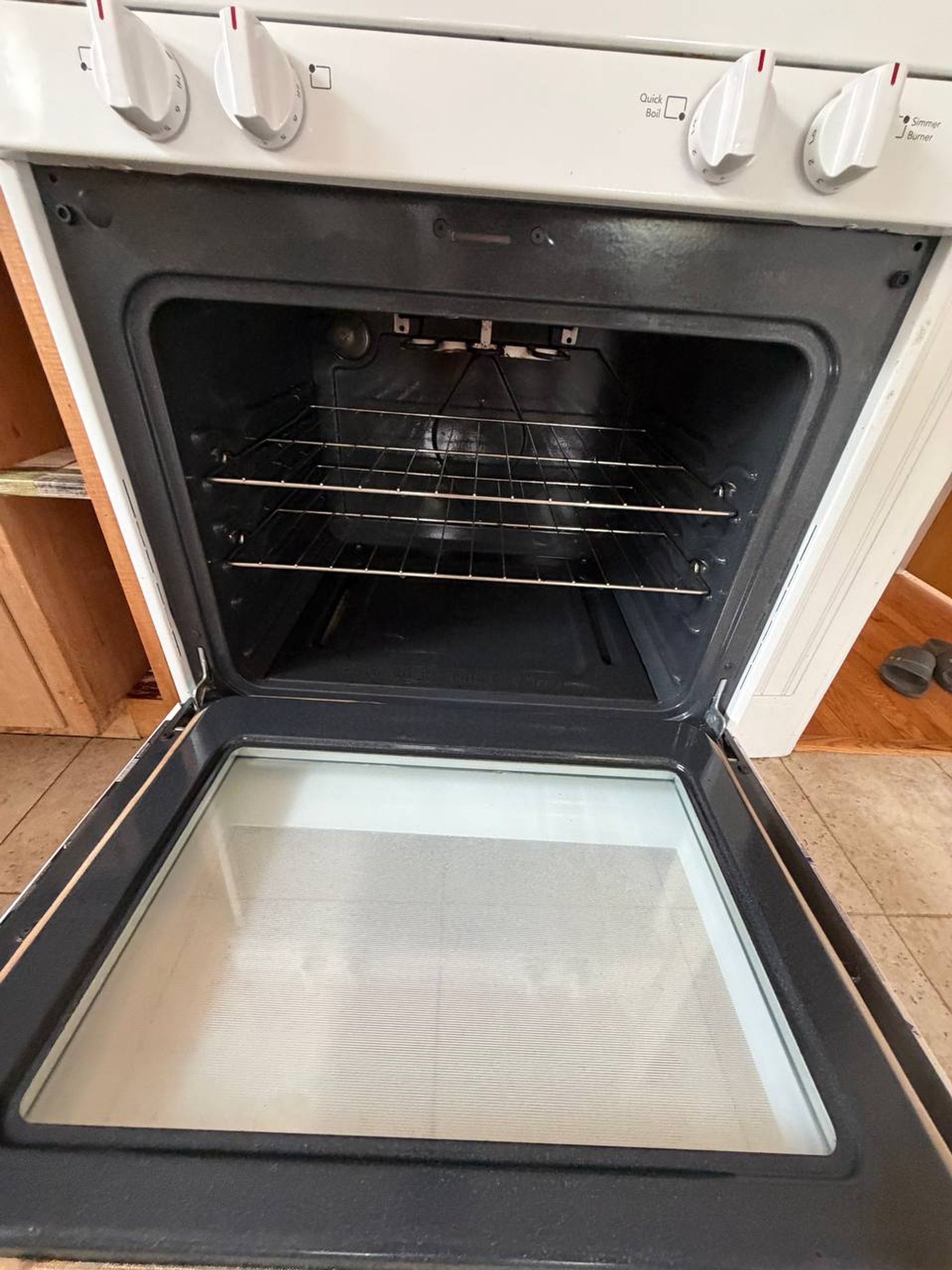 Open white oven with clean racks and clear door glass