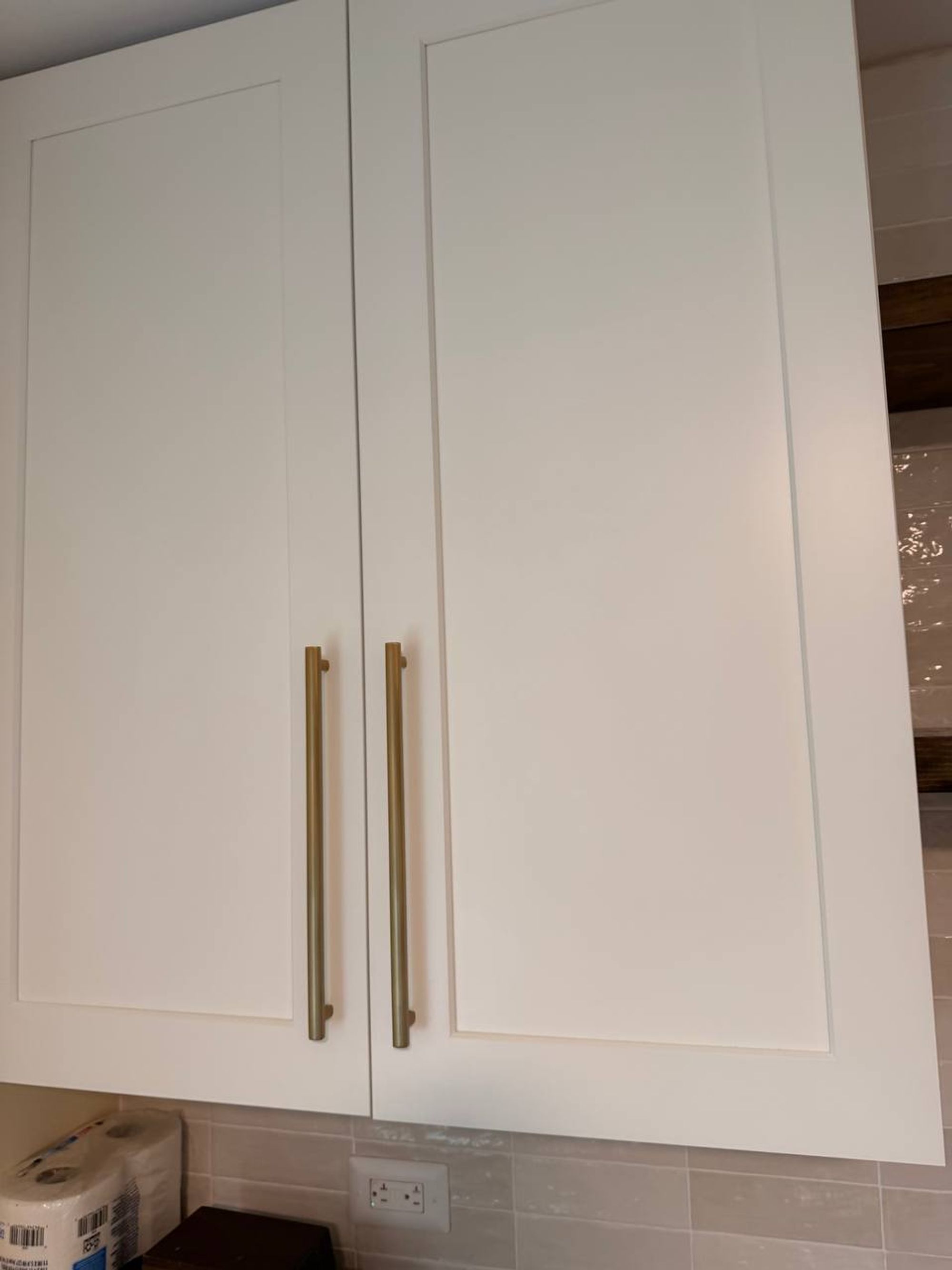 White shaker cabinet doors with long brass pulls