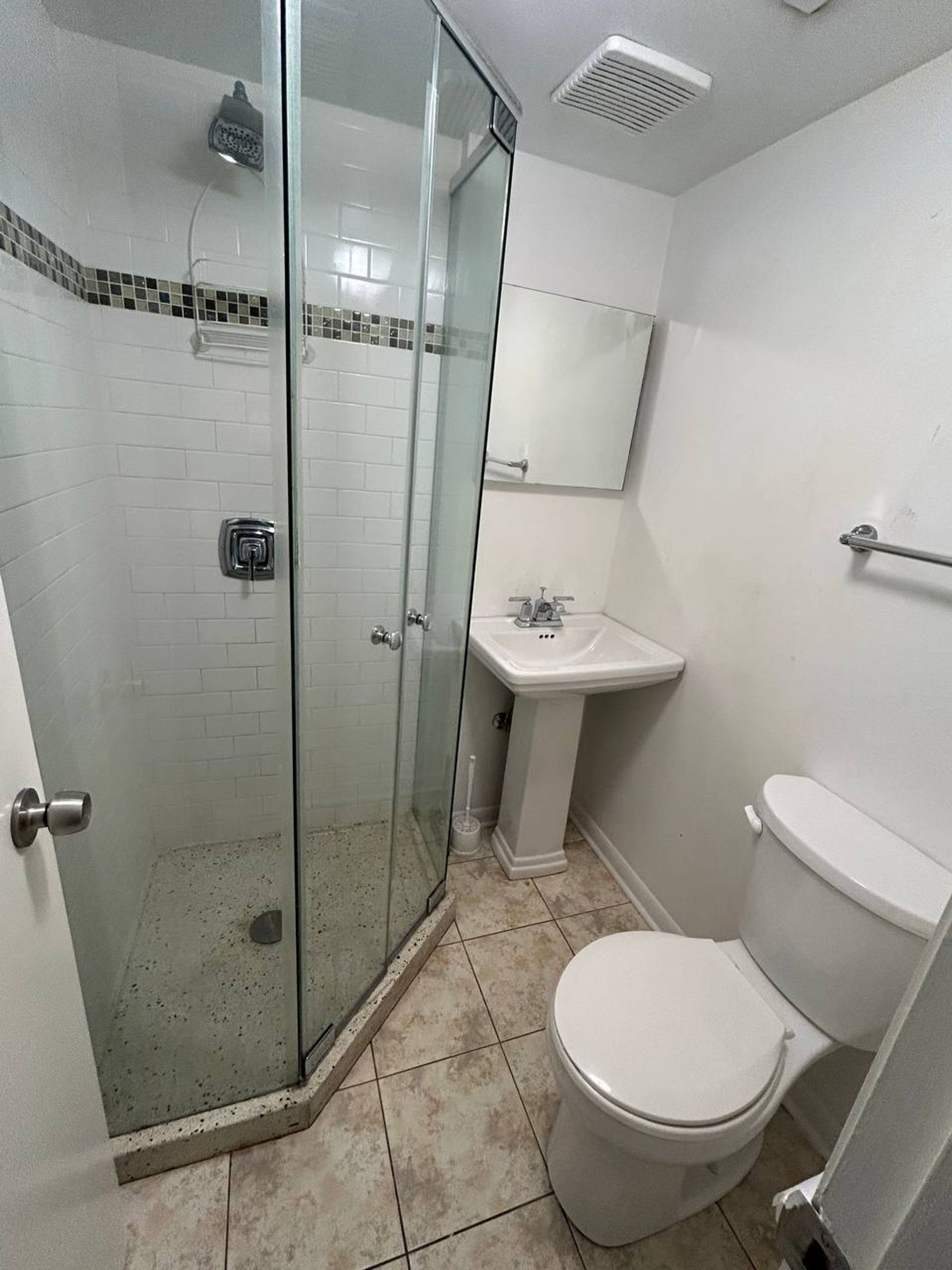 Small bathroom with corner glass shower and pedestal sink