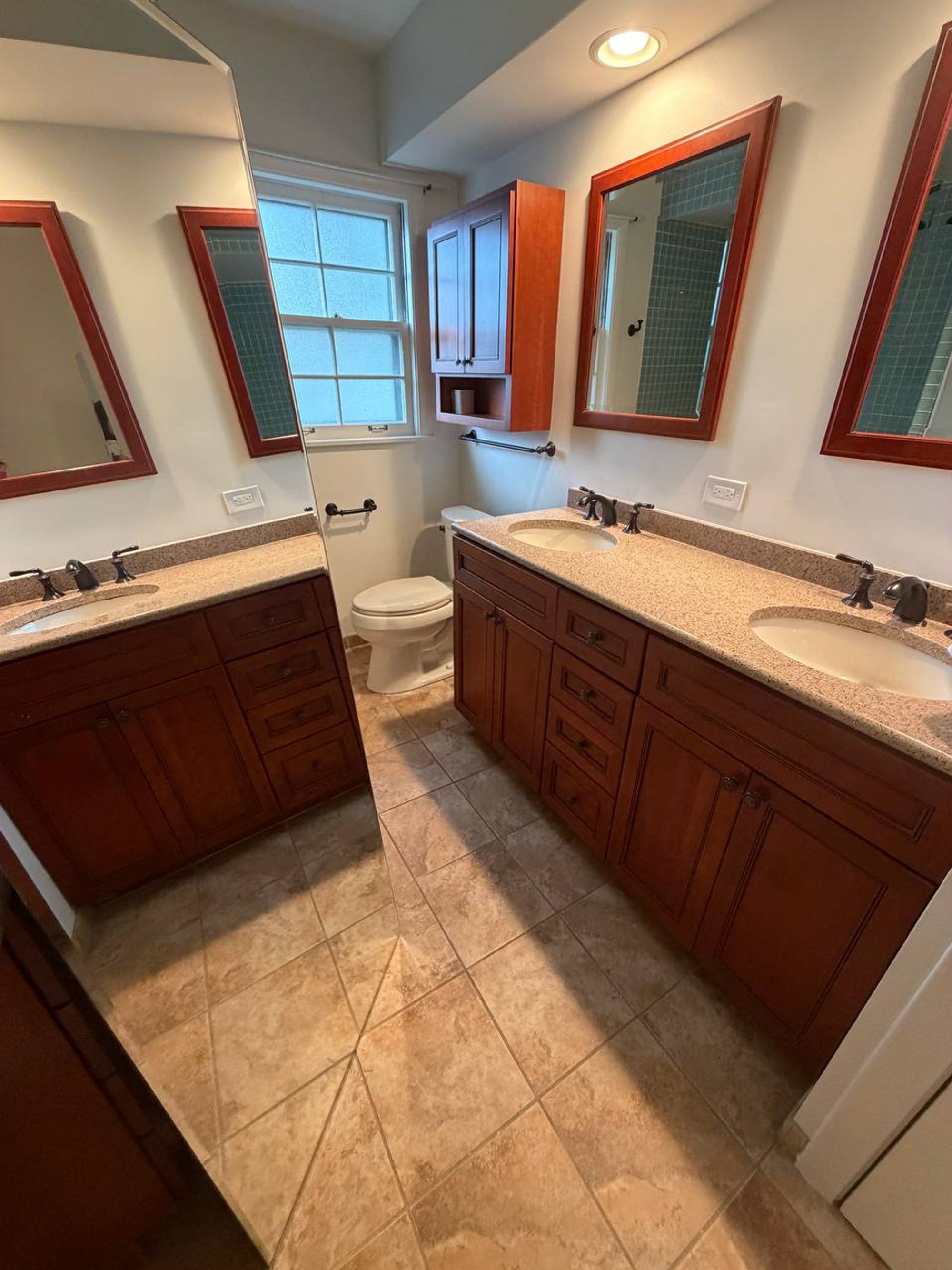 Bathroom with double vanity, granite counters and tile floor