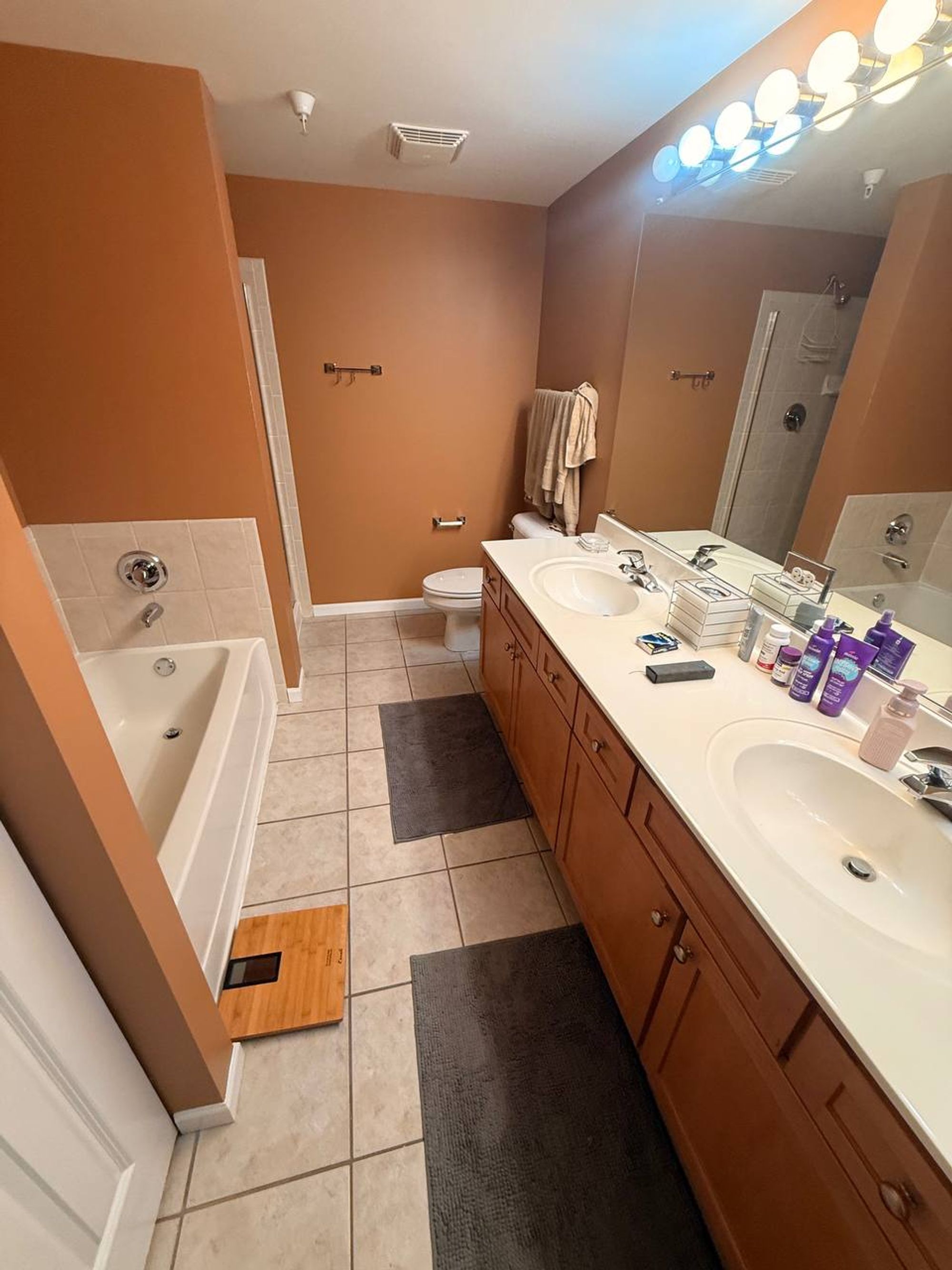 Bathroom with soaking tub, double vanity and beige tile floor