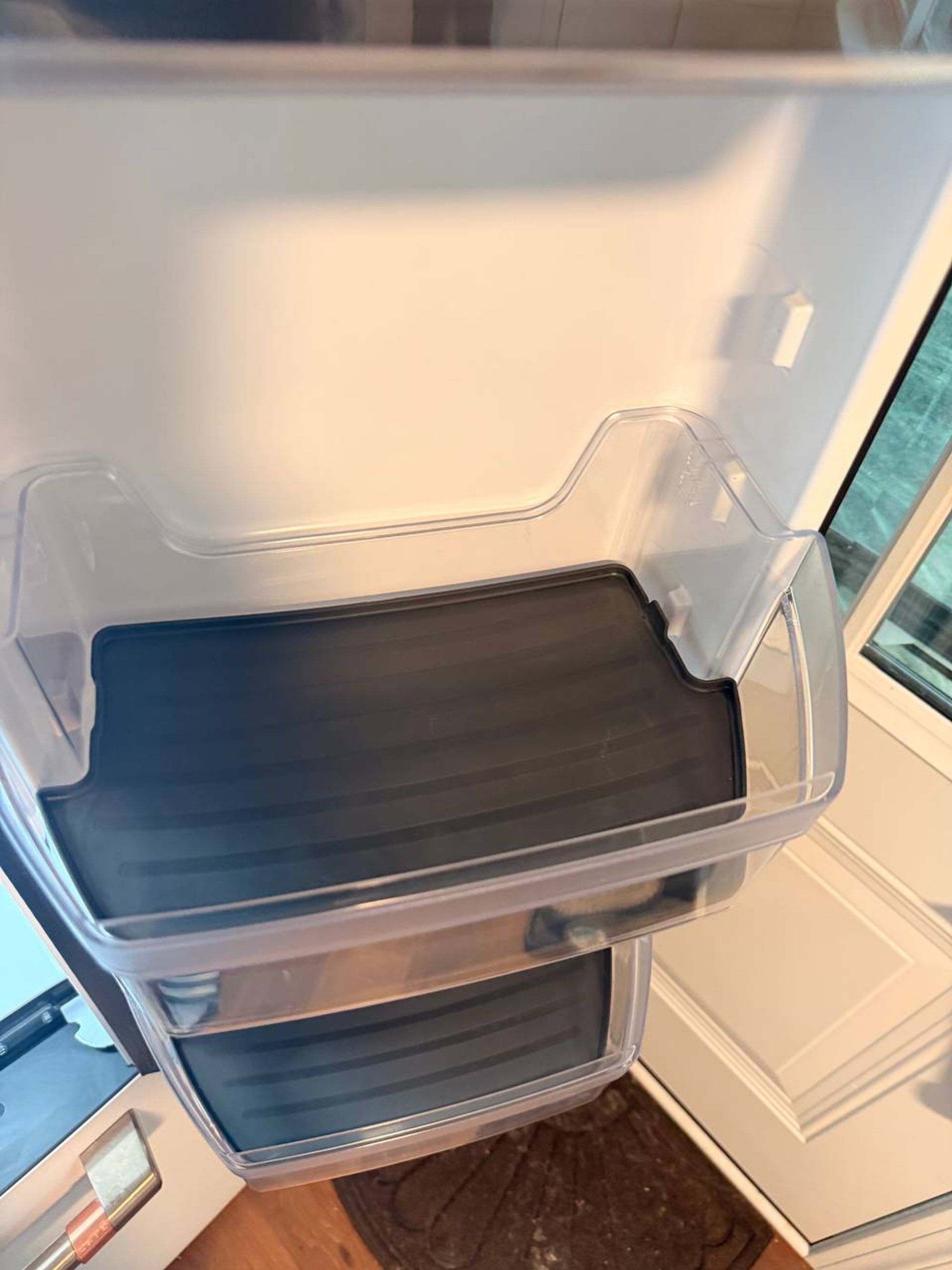 Empty refrigerator door bins wiped clean with dark liners