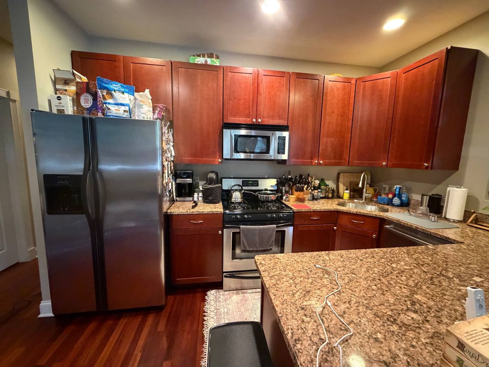 Kitchen with cherry cabinets, stainless fridge and granite peninsula