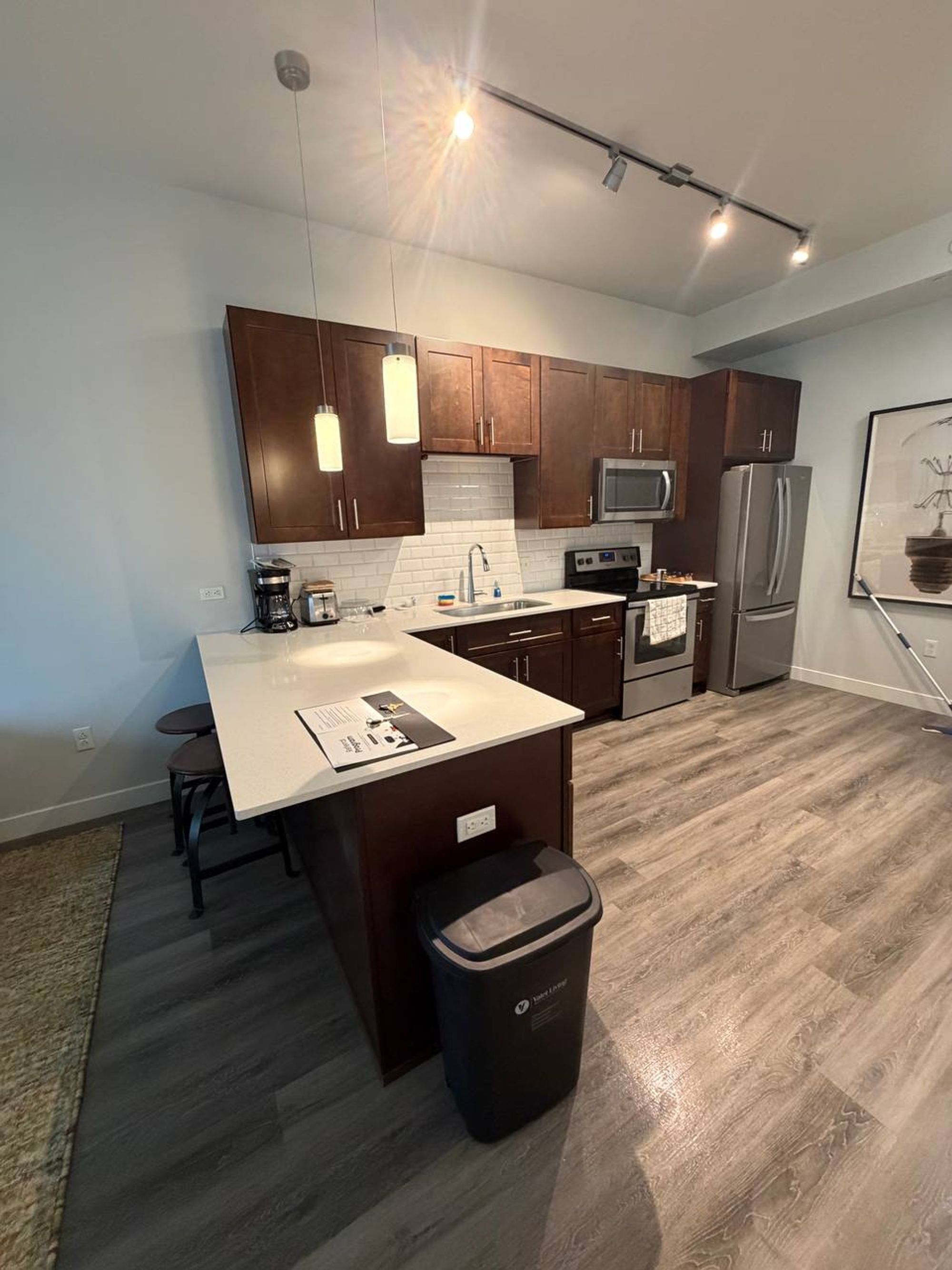 Open kitchen with dark wood cabinets, peninsula counter and steel appliances