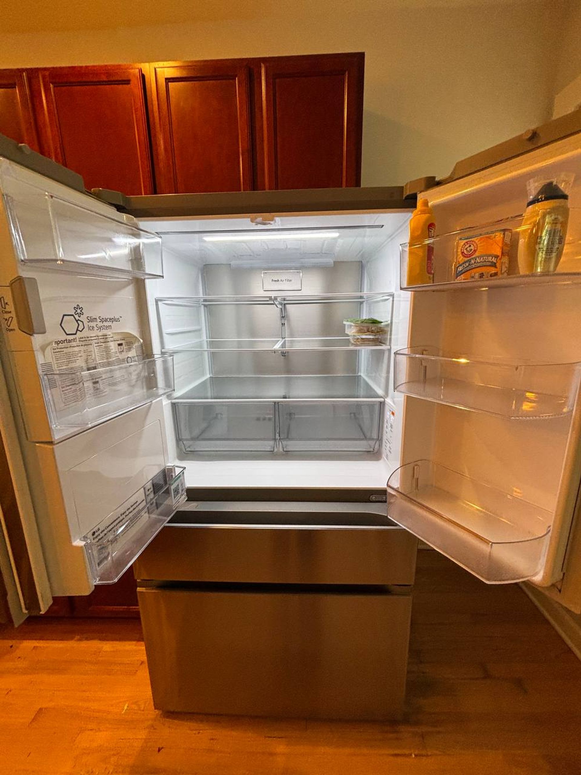 French door fridge open with clean shelves and door bins