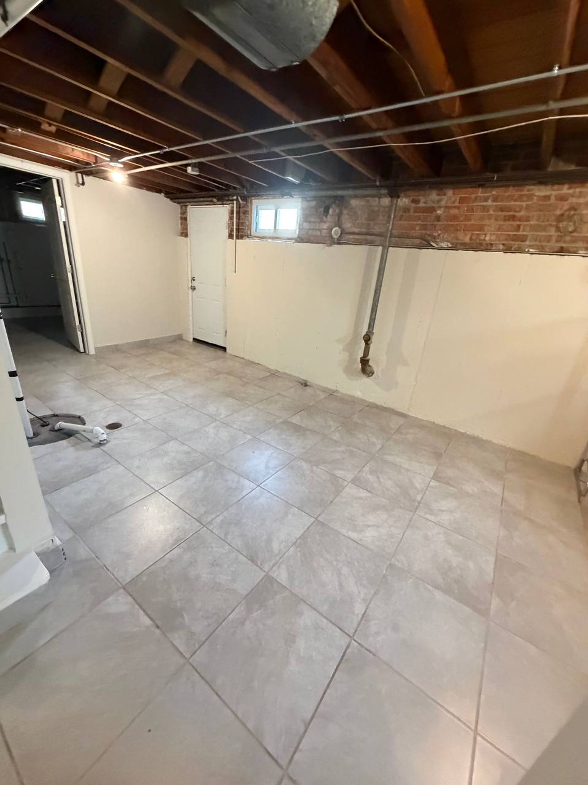 Open basement utility area with tiled floor and exposed ceiling