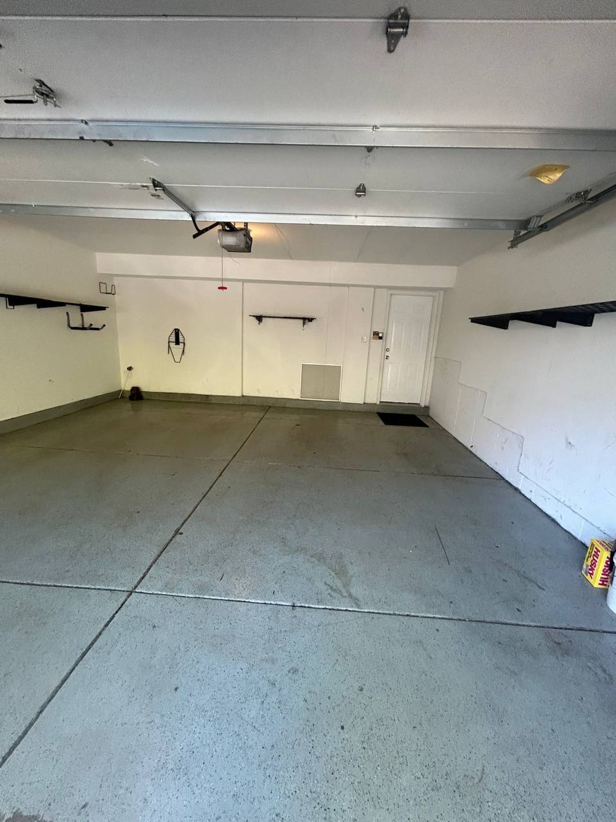 Empty two-car garage with swept concrete floor